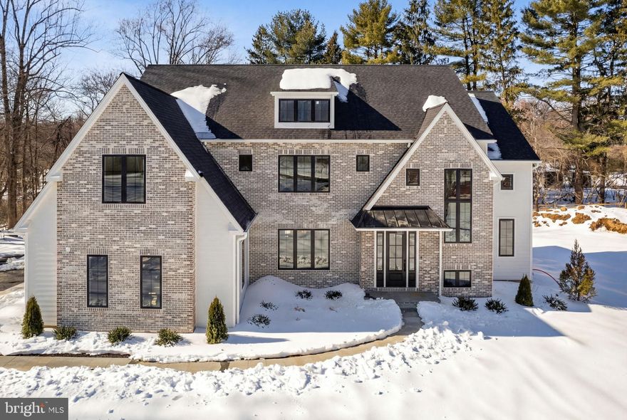 Private. Brand New. Move-In Ready.
A rare opportunity in Lower Gwynedd, this stunning luxury new construction is tucked at the end of a private lane, offering exceptional privacy, timeless architecture, and modern design—nearly 6,000 square feet of beautifully finished living space with nothing left to do but move in. Step inside to wide-plank European oak hardwood floors, 10-foot ceilings, and a dramatic coffered great room ceiling that instantly sets the tone for elevated everyday living. The open layout is designed for how people truly live today—connected, comfortable, and ideal for entertaining. The chef’s kitchen anchors the home with Sub-Zero and Wolf appliances and an effortless flow for hosting. Just beyond, a custom scullery/bar and secondary prep area creates a natural gathering space for cocktail prep, beverage storage, and serving—allowing the main kitchen to stay polished while the party unfolds. The space flows seamlessly to a covered veranda and expansive sundeck, perfect for indoor-outdoor entertaining, quiet mornings, or relaxed evenings with friends and family. A first-floor study with a full bath offers flexible living—ideal as a private home office or guest suite. The sun-filled finished lower level expands your lifestyle options with space for a game room, home theater, fitness studio, or wellness retreat. Upstairs, the owner’s suite is a serene, spa-inspired escape designed for true relaxation, while the junior lounge provides a stylish retreat for family or guests.
Located in the Wissahickon School District and minutes from top private schools, this home also offers exceptional convenience. Enjoy close proximity to Whole Foods, Starbucks, Ambler’s popular restaurants and boutiques, Route 309 shopping, the PA Turnpike just six minutes away, and the Ambler train station for easy commuting.