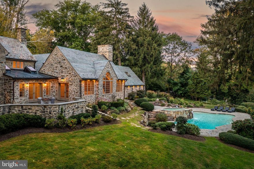 Breathtaking gated estate and restored Walter Durham masterpiece. "Braebank” is a historic and architectural treasure renovated completely to the highest luxury standards. Perched atop 6.67 sweeping acres of utter privacy and lush views, the home’s quintessential fieldstone exterior is finished with slate roof, copper gutters and wrap-around flagstone terraces that embrace the tranquil setting at every turn. The stunning grounds are punctuated by a trickling creek, gazebo and a glistening pool with spa and waterfall positioned to overlook the sun-filled views. Tucked on a quiet road, shared by some of the Main Line’s finest estates, pull up to the iron privacy gates completed with gas lanterns and down to a motor court lined with original stone walls and ending at a five car garage. The exquisite and timeless exterior echoes the breathtaking interior. No stone was left unturned in raising this timeless treasure to the finest modern day standards. Walk through the classic original door to a foyer that warms you with original wide-plank hardwood flooring. The elegance of the home is immediately showcased by a curved staircase framed by a striking and pristine Schoenbeck crystal chandelier. From the foyer, step down to a living room with soaring ceiling heights, original built-ins and molding, fireplace, glorious light with exposure on three sides and french doors to the grounds. A Mahogany office is completed with exquisite millwork, fireplace, wrap-around built in shelves and also steps out to the terrace. Both the Living Room and Study are quintessential Walter Durham features. A grand dining room is large enough to fit the extended family. It is finished with beautiful molding and overlooks the rolling hills with a large bay window. The family room could have been plucked from the pages of a design magazine with a dramatic cathedral ceiling, exposed trusses, floor to ceiling stone mantel and Palladian window overlooking the glimmering pool and grounds. A flowy, open layout that is ever sought after but hard to achieve in these elegant old stone houses connect this exquisite family room to a spectacular kitchen and breakfast room space. Also finished with a vaulted ceiling, the breakfast room is drenched with light from skylights and glass paneled double doors to the terrace. THe kitchen is fit for a gourmet with a large center island and high-end stainless-steel appliances. Custom white shaker cabinets and quartz countertops finish this kitchen with the utmost style and taste. Upstairs, the primary suite boasts another vaulted ceiling, an extremely rare feature for a home of this era. A large walk-in closet awaits the custom finishes of the Buyer and the primary bathroom has deep soaking tub, large tile shower with frameless glass door and double vanities. A private terrace completes this bespoke primary suite. Two additional bedrooms both with renovated ensuite bathrooms are in close proximity to the Primary. Further down the hallway, two additional bedrooms share a jack and jill bathroom and a cozy homework space. Another standout feature, the second floor is finished with a warm and light filled bonus room, which has its own entrance to the outside. Perfect for an upstairs family room, au-pair space or fancy expanded office.  Off the kitchen, a finished basement boasts a full bathroom and room enough for gym and a theater and additional hangout space. This grand project has been completed masterfully by a reputable Main Line builder who specializes in historic renovations. Utterly tranquil and yet centrally located with close access to major roadways, shops, train lines. Award winning Lower Merion School District. Includes partial house generator.