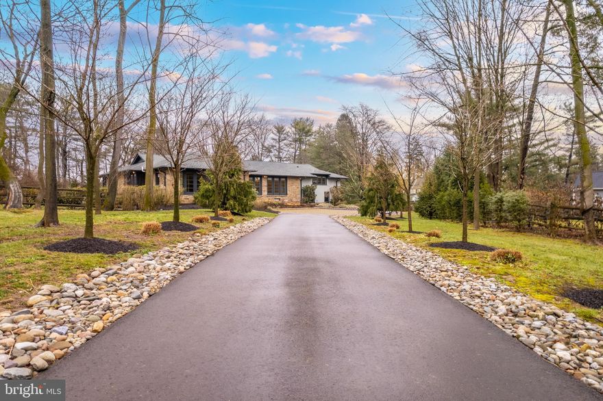 Experience the tranquility and privacy of your own oasis with this stunning, modern renovated rancher on a sprawling 1.1-acre lot. As you drive down the cherry blossom lined driveway, you'll be welcomed by a beautifully landscaped property that exudes luxury and comfort. Step inside and be greeted by an open concept living space flooded with natural light from floor to ceiling windows. Entertain guests in style on the back bluestone patio with a built-in gas grill, perfect for summer barbecues and gatherings. An additional outdoor side-courtyard area is surrounded by custom landscaping and stonework which leads to your very own salt-water pool! The main floor of this 4 bedroom and 3.5 bath home features 2 en suite bedrooms separated from the main living space with french doors, offering a sense of privacy and relaxation. The spacious primary suite has custom wardrobe closets that lead into the sophisticated en suite bath with heated floors and heated towel racks for ultimate comfort. For those who love to cook, this chef's dream kitchen features sleek custom cabinetry, top-of-the-line Wolf & Thermador appliances, as well as a Miele built-in coffee maker and microwave. The breakfast room, with heated floors off of the kitchen, provides an inviting atmosphere for casual dining, with custom built-in shelves equipped with a Sonos sound system for the ultimate dining experience. On the second floor, you will find two additional bedrooms with tons of natural light and ample closet space. Additionally, the second floor boasts a bonus laundry room, and a luxurious bathroom. The basement offers plenty of space for a home office, playroom, or exercise room with additional laundry facilities, storage space, and a kitchenette. Plus, enjoy the convenience of a heated 2-car garage. Don't miss out on the opportunity to own this stunning property that offers a unique blend of modern luxury and natural serenity.