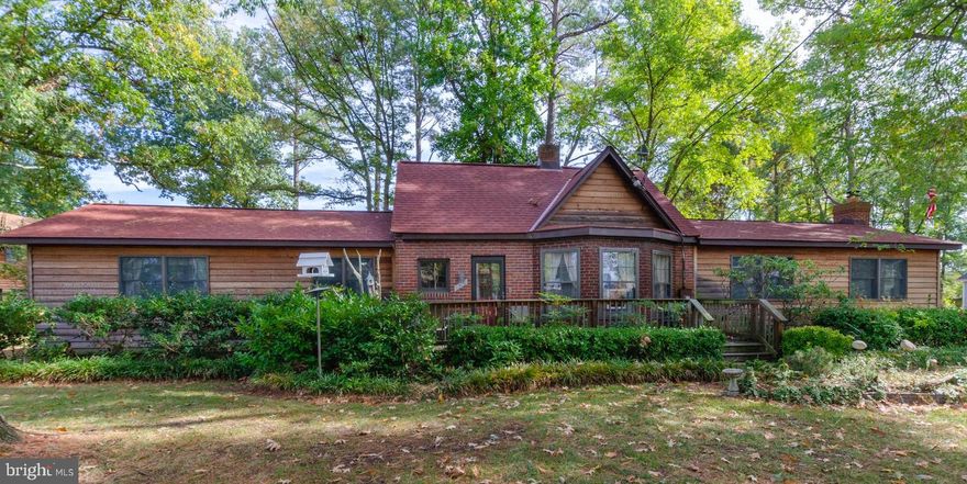 This charming cottage sits in a woodland setting with 3 full lots for a total of over 20,000 square feet.    The woodland setting caters to our feathered friends with birdhouses everywhere on the property.  The grounds also feature a well-maintained koi pond--with a roof to keep the local bald eagle pair at bay.  The 3 bedroom 1.5 bath main house makes you feel that you are in a mountain retreat with cozy hand-hewn wood features. Its large great room is a perfect place for family and friends.  The house is at a great location on the Point equidistant between sunrises on the river and sunsets on the bay.  It is an easy stroll and certainly within golf-cart driving distance to all of the town's amenities like the town's boat ramp, restaurants, beaches, shops and more.  The adjacent property is owned by the same seller and is also for sale.  It is an over-sized 3 bay garage with a large 2 bedroom, 1 bath apartment above the garage.  The original listing for the house included the garage/apartment.