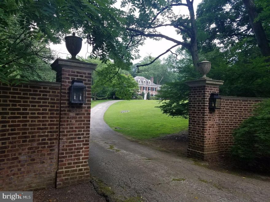 ANGELCOURT-is a beautiful 7 bedroom, 5.1 bathrooms brick Georgian mansion set in a stunning setting on a hill in Bryn Mawr on 3.37 acres above Dove Lake.  Built in 1928, this unique property is close to everything but feels like a country home thanks to mature trees, shrubs and expansive grounds that ensure privacy and serenity amidst neighboring open spaces. From the moment you pass through the brick walled entrance to the drive one cannot help but  be captivated by the singular beauty, charm and warmth of the spectacular home. The circular drive takes you up to the front door, or beyond it to the parking courtyard and garage. The formal front door opens into a gorgeous center hallway through to the terrace, and with a grand staircase to the second floor.  To the left is a large formal living room with fine woodwork and paneled fireplace, and windows on three sides, including a bay window overlooking the formal English garden. Through the living room, down two steps through an archway, is a paneled library with built-in bookcases and its own fireplace, and door to the terrace and garden. There is a powder room at the rear of the center hall. Up the center hall staircase to the second level, you'll find the master suite with fireplace and en suite bath and dressing area, another bedroom with a fireplace and en suite bath, and three other bedrooms (one with a fireplace) with 2 additional full baths, as well  as the laundry room. The fireplaces in the bedrooms are faced with antique Delft tiles.  Continuing up the center hall staircase one comes to the third level with two more bedrooms and a hall full bath.The expansive grounds to the rear of the house include a large flagstone terrace adjacent to the house, a formal sunken English Garden with fountain, another expanse of lawn and flower beds, and at the rear of the property, a private 44' pool and pool house surrounded by towering trees and shrubs. Mature trees ring the entire property to provide complete privacy.  House and property being sold "AS IS".