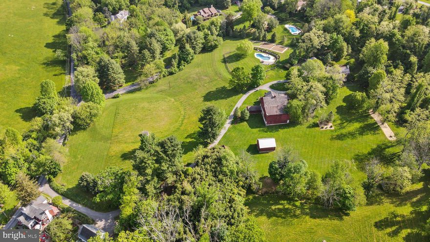Your dream of owning a historical, country estate can now be a reality with 1020 Wylie Rd in West Chester. This late 1700s - early 1800s estate offers a 5 bedroom, 2.2 bath Serpentine Stone farmhouse with 6 fireplaces, plus a 1 bedroom, 1 bath studio, bank barn with 13 stables and more. This private getaway is nestled perfectly on 10 acres, yet within minutes to major routes and amenities, and in the highly sought after Unionville-Chadds Ford School District. From the moment you make your way up the driveway past the large, circa-1820s, picture-perfect stone barn and 13-stall horse stables you immediately feel like you have arrived home. When on the front porch, stop to take in the breathtaking and private 360 degree view of nature. Enter through the detailed front door with an original transom window to be greeted by original wide plank wood floors that lead into your inviting living room. The living room is outfitted with a wood-burning fireplace with a period-specific accented mantel, built-in shelving, and oversized windows with deep sills that let in an abundance of natural light. Follow the paneled wall down the hall to find your convenient half bath. Continue into the home's most original space, used as a keeping room, with a large functional walk-in wood fireplace and a tucked away staircase. From here you can either head into the ultimate drop zone/mud room area equipped with a laundry room with accented built-in cabinets, or head into the massive kitchen. The modern kitchen offers a two-seater island, abundance of storage, curio cabinets, stainless steel appliances, and a 6-burner gas stove. From the kitchen you can also gain access through glass pocket doors to the cozy great room with a stone wood-burning fireplace, or enter through a swinging door to head into the formal dining room that also features a wood-burning fireplace with a detailed mantel. Both the great room and formal dining room lend access to your screened-in porch that overlooks the rolling hills that are your land. Head up the magnificent staircase to the second level where you will find your owner's suite oasis, equipped with a private deck, custom-shelved walk-in closet, and your private bath featuring two separate sinks and a glass stall shower. Also on this second level you will find three more generously-sized and well spaced bedrooms, (two with yet more charming wood-burning fireplaces; one featuring a gorgeous built-in), your half bath, and a spacious full hall bath with wood floors, his and hers sinks, medicine cabinets, and a shower/tub combo. Your third level offers an oversized loft area with an abundance of natural light that can be used as a 5th bedroom or office space. The third level also features a separate unfinished attic space perfect for storage. Not to mention the large easily-finished basement that provides you with even more storage space. Head outside to the two-car garage that is attached to the sizable, fully equipped studio efficiency with a loft and private patio space. Use this separate guest house as an in-law retreat, to host out of town guests, or as a studio space. In addition to the two-car garage you have an abundance of parking, including a roundabout to make navigating in and out a dream. Follow the short thoughtfully landscaped path to the immaculate fenced-in inground pool with a paver patio that overlooks over 100 acres of open space where the Battle of Brandywine took place and backs to the Firethorne Estate community's wooded open space. It's time to check your dream home off your wishlist, schedule your showings TODAY!