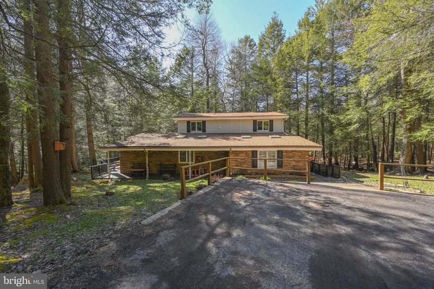 Nestled on 1.52 private acres with 500 feet of frontage on Deep Creek Lake, this 5-bedroom, 4.5-bath home combines comfort with exceptional waterfront living. The open floor plan features soaring two-story ceilings with exposed beams, wood flooring, upgraded countertops, and a striking brick fireplace. Outdoor spaces include multiple decks, balconies, porches, and a hot tub—perfect for entertaining or relaxing while taking in serene lake and wooded views. With private access and riparian rights, enjoy year-round activities, from kayaking and swimming in the summer to peaceful lakefront living in every season. Conveniently located just minutes from Wisp Resort, shopping, dining, and local attractions, this property truly offers the best of Deep Creek Lake living.