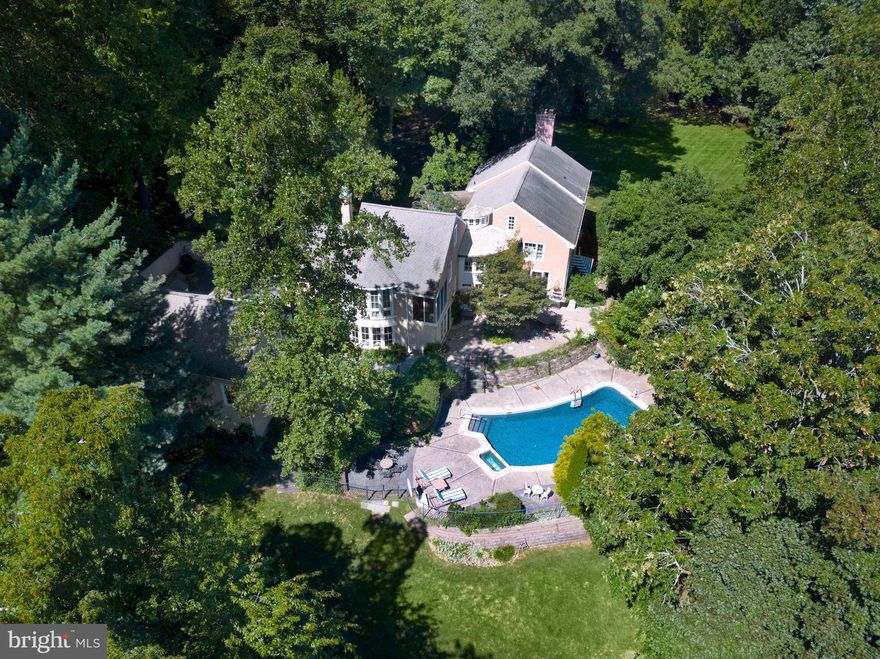 Welcome to 1121 Barberry Road, an exceptional French Country estate home designed by the celebrated architect Walter Durham and thoughtfully expanded to blend historic elegance with modern luxury. Located on one of northside Bryn Mawr’s most coveted streets, near the charming village of Gladwyne, this distinguished property offers both tranquility and easy access to major transportation routes for a convenient commute to Center City Philadelphia.
 
Enter through the bright, welcoming foyer, where you’ll find access to the main living spaces and the first of two main floor powder rooms. Every room enjoys breathtaking views of the expansive grounds, which are beautiful in every season on the year. The spacious living room features a large wall of windows and a fireplace, perfect for gathering with family and friends. A dining room awaits for elegant dinners, while the generously sized home office with a bay window and custom built-ins offers a serene workspace. The gourmet kitchen is appointed with stainless steel appliances, a large island with a gas cooktop, and granite countertops, opening to a light-filled breakfast area with curved windows that overlook the swimming pool. Beyond the breakfast area, the family room, complete with built-in cabinetry and a second fireplace, creates a warm setting for relaxation and entertaining. A mudroom with the adjacent second powder room completes the first floor.
 
Ascend to the second floor by either of two stairways or via an elevator, where the luxurious primary suite and four additional bedrooms await. The primary bedroom is generously sized and features picturesque views from both a bow window and screened deck that overlook the pool and grounds. The primary suite also features a loft area, a spacious walk-in closet and an en-suite primary bathroom that offers a soaking tub and separate shower. The four additional bedrooms include one with an en suite bathroom, one served by a hall bathroom and two of which share a Jack-and-Jill bathroom. The convenience of a second-floor laundry room completes this level.
 
The lower level of the main house offers a fully finished space with a decorative fireplace and a full bathroom, providing a versatile area for recreation and entertainment. A breezeway from the first floor leads to a two story addition that further enhances the estate’s functionality and appeal. This structure includes a three-car garage on the main level, with a fully finished second level that features a recreation room and full bathroom, perfect as an exercise or entertainment area or for conversion to an in-law suite.
 
Set on over 2.5 acres of beautifully landscaped grounds, this property includes exquisite gardens, a pond with a charming walking bridge, and a private swimming pool. Experience unparalleled Main Line living in this refined Walter Durham masterpiece, where timeless design meets luxurious modern amenities.
