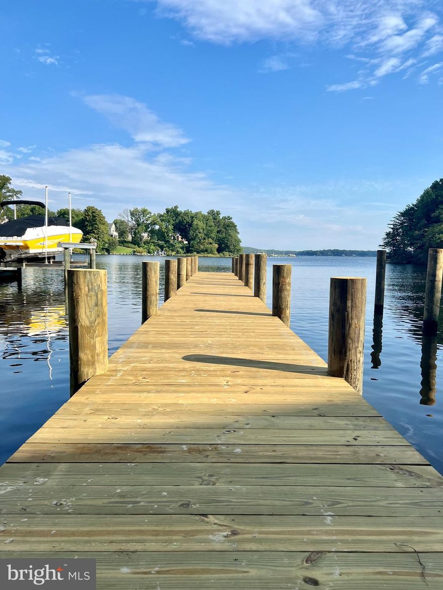 Price adjustment! NEW CONSTRUCTION waterfront, completed and ready for immediate occupancy. This beautiful home in Arnold, Maryland spans approximately 5000 square feet over 4 levels with 4 large bedrooms and 3 1/2 bathrooms. Details were carefully selected and all rooms are positioned to maximize the EXPANSIVE water views, as water can be seen from nearly every window of the property. The main level offers a bright open floor plan with high ceilings. The chef’s kitchen has GE stainless steel appliances, quartz countertops with a stunning waterfall center island, subway tile backsplash and soft close white shaker style cabinets. Kitchen cabinet hardware will be chosen by the buyer. The kitchen is open to a large family room and a formal dining room with plenty of room for entertaining family and friends. Cozy up to the fireplace with a custom mantle. Watch the sunset from the kitchen and family room, or step out to the main level deck for a breathtaking panoramic view of Cool Spring Cove and the Magothy River. The second level of the home features maple hardwood hallway flooring, two spacious bedrooms and the master suite. The master suite offers a spa bathroom with dual vanities and soaking tub with a spacious 10x14 walk-in closet/dressing room. The additional bedrooms share a full luxurious bath. The third floor with bamboo flooring is set up to offer either two bedrooms or a sitting room and office. These rooms can enjoy a luxurious full bath with a large frameless glass shower. The grand basement in this home with towering 9’ ceilings could serve several purposes including a game room, theatre, recreation room, work out area, plus plenty of storage. Take notice of the rough-in for a bathroom and bar/sink service. The basement walks out to another oversized deck with a personal pier with 9’ MLW and multiple slips. Additional interior features include: Anderson 400 series double hung and casement style windows, High efficiency 16 sear 2-ton heat pump(basement and first floor) with 10k electric emergency heat, High efficiency 16 sear 2-ton heat pump with 10k electric emergency heat(second floor and attic), Wi-Fi remote monitoring and control with GeoFencing, sprinkler system, cable and Cat 5e wiring, tankless water heater, recessed lighting, high end ceiling fans, porcelain, mosaic and ceramic tile in bathrooms, hardwood floors throughout, bamboo flooring on third floor office and sitting areas, carpet in second floor bedrooms, upstairs laundry room with washer/dryer, and insulated garage. Outdoor features include: RARE Private Riparian Sandy Beach, NEW stairs, New pier w/ 9' MLW, New 70ft structural retaining wall, NEW fence, 30-year architectural Tamko Heritage roof shingles, James Hardi smooth lap siding (light mist color) with PVC Trim, NEW stamped concrete driveway, rain gardens, landscaping, and more... Enjoy the comfort of being in close proximity to exceptional Broadneck schools, the city of Annapolis, Gibson Island, notable waterfront restaurants, shopping, water activities, and major commuter routes. Don’t miss this rare offering! Contact listing agent for floor plans, spec list, and more information.