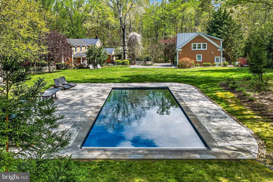 Set on over 2 private acres, this exceptional Clifton property offers the perfect blend of charm, modern updates, and unmatched versatility with no HOA and a prime location just minutes to historic Clifton, the VRE, commuter lots, and Fairfax County Parkway.
The main home features a bright open layout, rich hardwood floors, custom moldings and woodwork, chic upgraded lighting, and an abundance of high-end upgrades and designer finishes throughout. An open foyer greets you and ushers you into a spacious living room boasting walls of windows, built-in bookcases, a cozy fireplace, and French doors opening to the lush rear yard. The dining room accented with board and batten and stylish lighting opens to the beautifully renovated kitchen showcasing a soaring cathedral ceiling, an abundance of white cabinetry, quartz countertops, stainless steel appliances, and abundant natural light. The main level also includes a dedicated office, bedroom, and a full bath, ideal for flexible living. A laundry room with front loading washer and dryer compliments the main level.
Upstairs, the spacious light filled primary suite offers a true retreat with vaulted ceilings, dual walk-in closets with custom organizers, and a fully remodeled luxury bath with a dual sink vanity, a frameless glass enclosed shower and high-end finishes. Hardwood flooring flows down the hall and into three additional bright and cheerful bedrooms sharing easy access to the well-appointed hall bath, bringing the main home to three full baths total.
A true standout is the detached two-car garage with a high-end apartment above, complete with dramatic vaulted ceilings, a kitchen featuring an oversized granite island with bar style seating, a loft area, and elevated finishes throughout, along with its own full bath. This space is perfect for multigenerational living, a private home office, guest suite, or income-producing opportunity.
Step outside to your own private retreat featuring two covered porches, a large patio area, and a shimmering heated in-ground pool with electronic cover and newly updated patio surround, ideal for entertaining or relaxing in total privacy. This lush, fenced property with vibrant expert landscaping surrounded by privacy plantings and woodlands also includes two separate sheds with electricity, offering excellent space for storage, a playhouse, hobbies, or workshop use.
This is a rare opportunity to enjoy the privacy and lifestyle of a Clifton estate with modern upgrades, flexible living options, and exceptional outdoor amenities, all in a highly sought-after and commuter-friendly location.