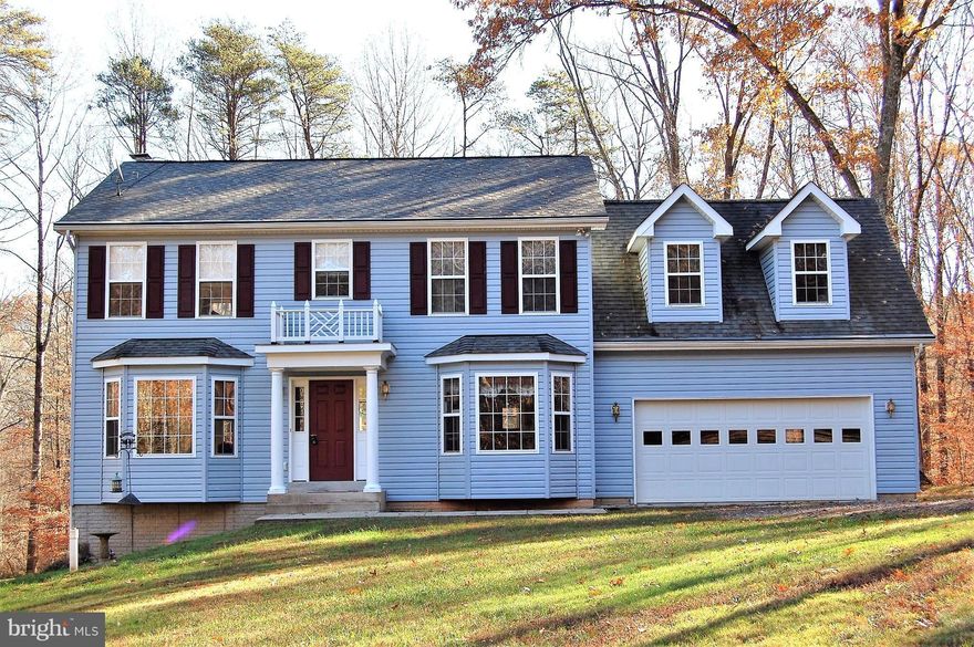 Motivated seller - Make an offer!  2-story colonial on gorgeous 5.21 ac wooded lot, Rear deck (33 x 12) great for entertaining. Crown molding and hdwd floors on entire main level. Warm up beside the wood stove in family rm, KIT has recessed lighting, lovely bay windows in DR, LR & BK area. MBR w/ sit area, vaulted ceiling & 2 WIC. 2 car gar with access door, unfin bsmt w/ walk out & RI plumbing.