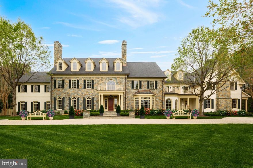 Round Hill is unquestionably one of the country’s most prestigious residential communities, its collection of estate homes set far back from the winding, estate fence lined streets. Amidst this rarified air stands a classic American fieldstone colonial prominently sited on two corner acres. Built by the legendary Ted Visnic, it is introduced via a sweeping paver driveway beyond motorized gates. Looking over a level, manicured lawn framed by immaculate and extensive hardscaping, the estate is a spitting image of the classic country home, embodying a certain familiarity and warmth. The sprawling 22,950 square foot floor plan is initially introduced with a grandiose greeting hall, whose elegant fireplace, double-height ceilings with mezzanine overlook and sturdy doric columns convey images of the triple Michelin-starred Inn at Little Washington. Any estate of this caliber ought to feature the obligatory banquet-sized formal rooms, in this case mirrored and connected via a spectacular arched transverse gallery. Said gallery terminates in the jaw-dropping two-story mahogany library. Its roaring fieldstone fireplace soars from floor to ceiling, while a fully-equipped wet bar overlooks the billiards room whose centerpiece is the Piper J-3 Cub suspended from the ceiling. Tucked off to the side is a replica of another American icon — Oval Office — serviced by twin formal powder rooms. The heart of the home’s informal area is the two-story, cathedral ceilinged, limestone floored chef’s kitchen. Furniture grade cabinets, marble countertops, a unique teak island and all top-end Viking/Sub Zero appliances are all par for the course. A cozy tea room and separate family areas complete the main level. The upper level primary suite is a residence in and of itself. Dual ensuite baths, each with new marble tilework and their own custom dressing rooms, create a peaceful, secluded oasis. Six additional bedroom suites are all sumptuously furnished with new baths, four of them boasting individual fireplaces and one featuring a unique loft space. The eighth bedroom suite located on the top level is adjacent to a large storage area, creating flexibility in the floor plan. The lower level is a true entertainer’s delight with every imaginable amenity present. From the new 22-seat home cinema with 168 inch screen to the indoor basketball court and fitness center, not a single detail has been overlooked. Rounding off the lower level are a private yoga room and three additional storage areas. Mechanical systems powering the home are all of commercial caliber, such as the 11 zone HVAC, new 50 year asphalt shingle roof, and temperature-controlled five car garage with space for lifts, EV charging station, air compressor, and separate vacuum system. As with any great estate, the grounds are every bit as extravagant as the rest of the home. The heated 40-foot lap pool with automatic cover is surrounded by meticulously landscaped grounds which form a lush, green wonderland. An English garden, rose garden, and organic garden are all interwoven with flagstone walkways, while the elegant pool house with cupola and half bath offers additional convenience. Numerous benches, hammocks, tables, and chair swings enable multiple pockets of total tranquility, all of which is illuminated after the sun sets. With every single feature contained in a gracious, tasteful package situated in a community which without a doubt ranks among the nation’s best, 11400 Highland Farm Court is arguably one of the most special homes ever made available.