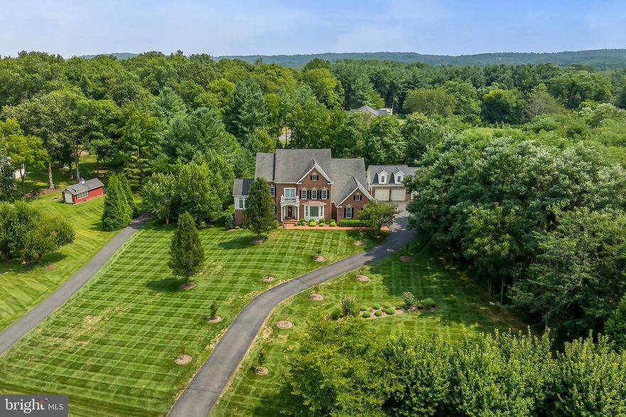 OPEN HOUSE SATURDAY AUGUST 24 FROM 1-3! 

When the right home hits the market, you know it.  Well, this is the one!  Conveniently located minutes from Leesburg/Beacon Hill, this luxury estate home will knock your socks off.  When you turn onto the meandering driveway, notice how this stately brick-front home welcomes you to come in.  Pulling up to the car park there are 6 garage bays, plus room for 2 car lifts in the detached garage, perfect for a car collector. 

A custom brick sidewalk welcomes guests to the front door while passing lush landscaping surrounded by a manicured lawn.

Be prepared to be wowed.  An impressive two-story foyer boasting refinished hardwood floors, upgraded trim, an oak staircase with a runner, and bespoke lighting sets the stage.  To the right is a banquet-sized Dining Room with crown molding and chair railing, and a Butler's Pantry (with beverage fridge) for staging formal meals.  To the left is a cozy Sitting Room adjoining an incredible Conservatory loaded with lots of natural light, two pairs of French doors, and a cathedral ceiling. This connects to the main-level library.  Moving into the spacious Family Room is an 11' ceiling with coffers and trim, tons of natural light, a two-sided gas fireplace, and HEATED tile flooring for added comfort.  Designed for the professional chef their guests will find a fully renovated high-end kitchen (2021).  Curated to work seamlessly, the custom cabinetry features slow-close doors and drawers, pull-out shelving on base cabinets, a custom pull-out spice cabinet, and a plethora of pantry space in the tall cabinets, including more pull-out shelving.  A wall of upper glass cabinets is there to display your collection!  Appliances are commercial-grade GE Cafe/Profile; dishwasher, microwave drawer, and bottom freezer/top fridge.  The range offers six burners, two lower ovens, and a custom hood (1200 CFM) which vents outside.  Custom pendants light up the oversized island which can seat up to 6 with added storage underneath.  A large breakfast room is just beyond and offers more natural light and a bespoke light fixture.  Hardwood flooring covers almost the entire main level.  Just off the kitchen is a well-designed custom mudroom featuring 3 cubbies and a wall of cabinets for hanging coats and extra storage.

Heading up the rear staircase is an upgraded handrail with metal spindles and more hardwood flooring.  There are three spacious bedrooms, one with an ensuite bath and walk-in closet while the other two bedrooms share a buddy bath.

The jaw-dropping Primary suite presents hardwood flooring, a tray ceiling, a Sitting Room, Dual Walk-In closets with custom cabinetry, plus a dressing area.  To top this suite off is a fully remodeled dream spa-inspired bathroom which should be in a high-end hotel.  Inlaid tile and a heated floor welcome you in, while a zero-entry custom shower features a rain showerhead, a handheld, linear drain, an extended bench, and a frameless surround all calling your name.  A custom "Victoria and Albert" slipper freestanding tub with matching sinks, a double floating vanity with top mount sinks, and floor lighting set the mood.

The lower level features a large recreation room with natural light, a gym/bedroom, a full bath, and a custom Wine Cellar. The custom wine cellar holds a collection of approximately 600 bottles, made from cherry wood facing as well as cherry ship lap on two of the walls, locking mahogany glass door, dimmable lighting, a separate HVAC system, foam insulated walls, and a tile floor.  The backyard paradise offers privacy, a covered porch with a fan, a composite deck, a paver patio, a hot tub, and a fire pit with a sitting area.  There is room for a pool in this flat back yard too.  Lush landscaping surrounds you.  

Welcome Home!