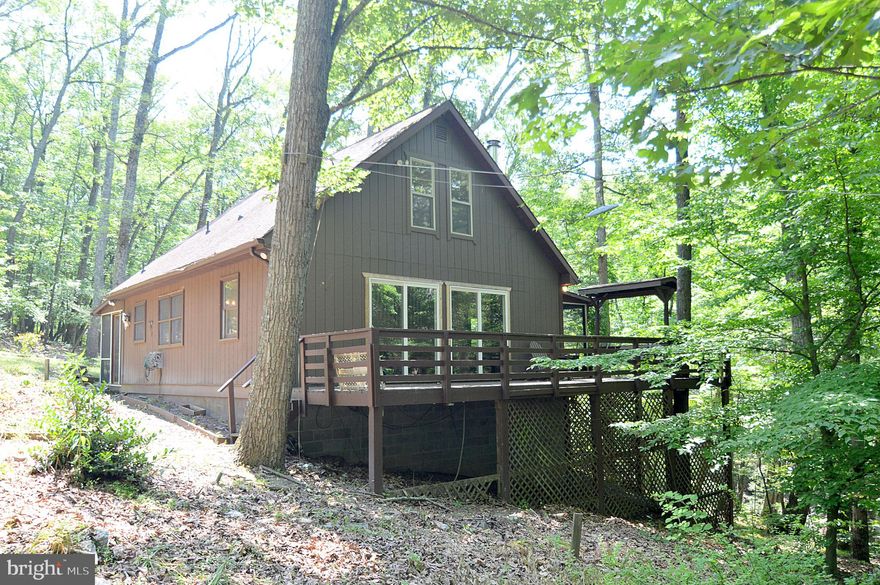 Very charming 3 bedroom 1.5 bath cabin on 3 acres. Offers a great location in a peaceful setting.  Fresh interior paint and flooring.  Newly remodeled kitchen.  Enjoy relaxing or entertaining on the wrap around decking and screened in porch areas.  A small stream runs through the property as well.  Central heat and air conditioning along with a wood stove makes it a comfortable place to be be.  A must see!