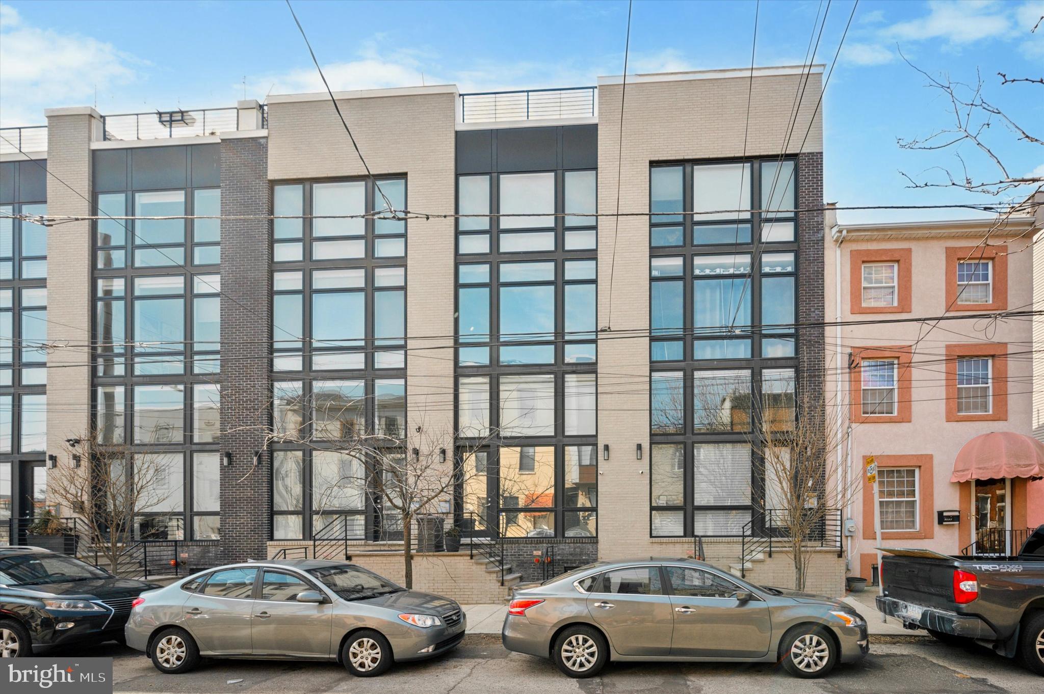 Welcome to this stunning, modern 4-story townhome in the heart of Olde Kensington, just steps from Fishtown and Northern Liberties. Offering sophisticated urban living with state-of-the-art finishes, this home features a dedicated master suite floor, two roof decks, and an oversized garage.
The spacious and sun-filled open-concept living area is perfect for entertaining, with two-story, floor-to-ceiling windows that flood the space with natural light. The kitchen is a chef’s dream, complete with waterfall quartz countertops, stainless steel appliances, and abundant storage. Sliding doors open to a charming patio – ideal for enjoying your morning coffee.
Upstairs, you’ll find two large bedrooms and two full baths with plenty of closet space and ample natural light. The private master suite occupies its own floor, offering a luxurious walk-in closet and a spa-inspired bathroom that will make you feel like you're at a five-star resort.
Additional features include a finished basement, three half bathrooms, and a private garage for convenience and security. With two beautiful roof decks, you can take in the panoramic city views while relaxing or hosting guests.
Just five blocks from this home, you’ll find an array of incredible dining options, including Suraya, Mulholland & Sons, Kalaya, Laser Wolf, Pizzeria Beddia, Front St. Cafe, Fette Sau, and many more. A nearby park offers a pool and ball field for outdoor recreation. Plus, the Market-Frankford Line is just six blocks away—conveniently close for easy access to Center City, yet far enough to ensure a peaceful living environment without the noise.
This home truly has it all – modern finishes, abundant space, and a prime location. Schedule your tour today!