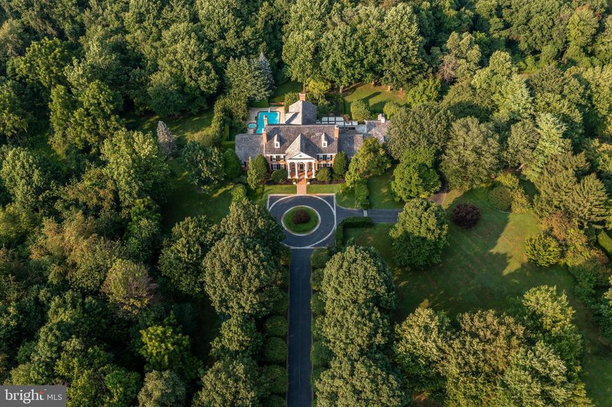 This magnificent Georgian home offers privacy and welcome to the discriminating buyer, with sought-after amenities inside and out. Set on 5.4 acres landscaped by award-winning Gale Nurseries, and with a new roof in 2019, this home offers resort-quality attributes: a paneled “Hunt Room” with 20-foot beamed ceilings and a wall of windows; separate exercise, billiards, and home theater rooms; a stone 3,200-bottle wine cellar; a pergola-shaded brick patio; and a private waterfall pool. The first floor is perfect for entertaining in formal living and dining rooms with fireplaces and views of the spectacular grounds; there is access via a stone staircase to the lower level’s wine cellar. The dramatic hunt room has a custom bar and Sub-Zero undercounter refrigerator/ice maker. The custom kitchen has cherry wood cabinets with glass-paned uppers, a hand-painted backsplash, and a large island with seating. Nearby is space for casual dining and a sunroom with a 12-foot coffered ceiling and brick fireplace. The main, first-floor bedroom has an en-suite bath with 2 closets, jetted tub, and separate shower. Two powder rooms, a home office with plentiful built-in bookcases, a mudroom/laundry room, and access to the three-car garage complete this floor. The second floor has three generously sized bedrooms with en-suite baths. A loft lounge overlooks the hunt room below. The walk-up attic provides an additional 2,000+ square feet, convertible to living space. An additional guest suite for a nanny or in-laws is above the three-car garage. The garden level offers space for all manner of entertaining: a home theater, brass-railed bar equipped with full kitchen, French bistro-themed seating, billiards room, private mirrored gym, and changing rooms and baths. This level opens to the well-tended 50 x 22-foot heated pool and attached spa. From the brick patio shaded by a pergola and climbing roses, enjoy the view of a butterfly garden, mature trees, and landscaping. The spacious outdoor area also includes room for a volleyball/badminton court. This one-of-a-kind home, with Radnor Hunt and other golf clubs nearby, is close to top schools, walking trails, and downtown Malvern. The nearby Paoli and Malvern train stations provide easy access to Center City, with Amtrak service to New York from Paoli more than 50 times each week. The airport is just 25 minutes away.