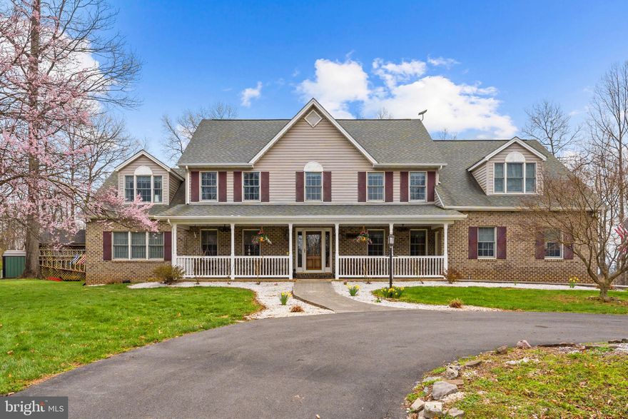 If you’re looking for a truly impressive property with unexpected benefits, welcome to 530 Laurel Grove Road. With nearly 6,000 finished square feet and five bedrooms and 5.5 baths, this home allows for easy gathering, relaxing, living, and entertaining—and includes a private in-law suite perfect for multi-generational living, guests, or rental potential. Ensconced in nature on 8.6 acres and surrounded by mature trees in a largely pastoral setting, this home offers peace and privacy, and the outdoor swimming pool
and surrounding decks add another layer of enjoyment. You’ll also appreciate how this Winchester location gives you access to everything you love about town without living right in the city. The Colonial’s façade is brick and siding with a welcoming front porch just waiting for you to sit and enjoy the scenery or rock a while on the porch swing. Once you enter, you have two options. The right takes you to the all the main level features amidst pleasing neutral paint colors you’ll find throughout the home. A formal dining room allows for generous seating but also extra display cabinets and buffets. The kitchen has a bank of cabinets, long counters, and a four-seat island that includes the range. More informal dining sits adjacent, along with an inset, built-in desk space with cabinets. This shared space opens to a cheerful, whitewashed sunroom with a handsome wood ceiling, giving you natural views plus access to the deck and pool areas. Another side leads into a family room with a dramatic, vaulted wood ceiling, cozy corner fireplace, and lots of room for comfortable furniture. Back in the foyer, turn left through a door to find the convenient in-law suite, complete with a living room, kitchen and dining area, laundry and storage, and a spacious bedroom with attached full bath and walk-in closet. Private and accessible, it’s also available furnished, if desired.
Upstairs houses the substantial owner’s suite with beautiful cherry hardwood floors and ample room for all your furniture. The ensuite features split vanities, beadboard wainscoting surrounding an appealing soaking tub, a walk-in shower, and water closet. A matching sitting room offers another pleasing, versatile space. Find three generous bedrooms and another two full baths on this floor. Downstairs is home to the fifth bedroom and attached full bath with an adjacent indoor, infrared sauna with chromotherapy benefits. A wood paneled den with hardwood floors and bar with a walk- out round out this level. Head outside and enjoy a large walkaround deck where seating and dining opportunities abound. Portions lead to the pool, hot tub, the backyard, and play areas. The home includes an attached two-car garage, but it’s a boon to have the detached, three-car garage, perfect for a workshop or car enthusiasts, or to utilize for additional storage. This home has been meticulously maintained and updated by only two owners and comes with multiple fuel sources to help with energy efficient heating and cooling. With space galore, comfort, privacy, and functionality, this is an amazing oasis near the city.