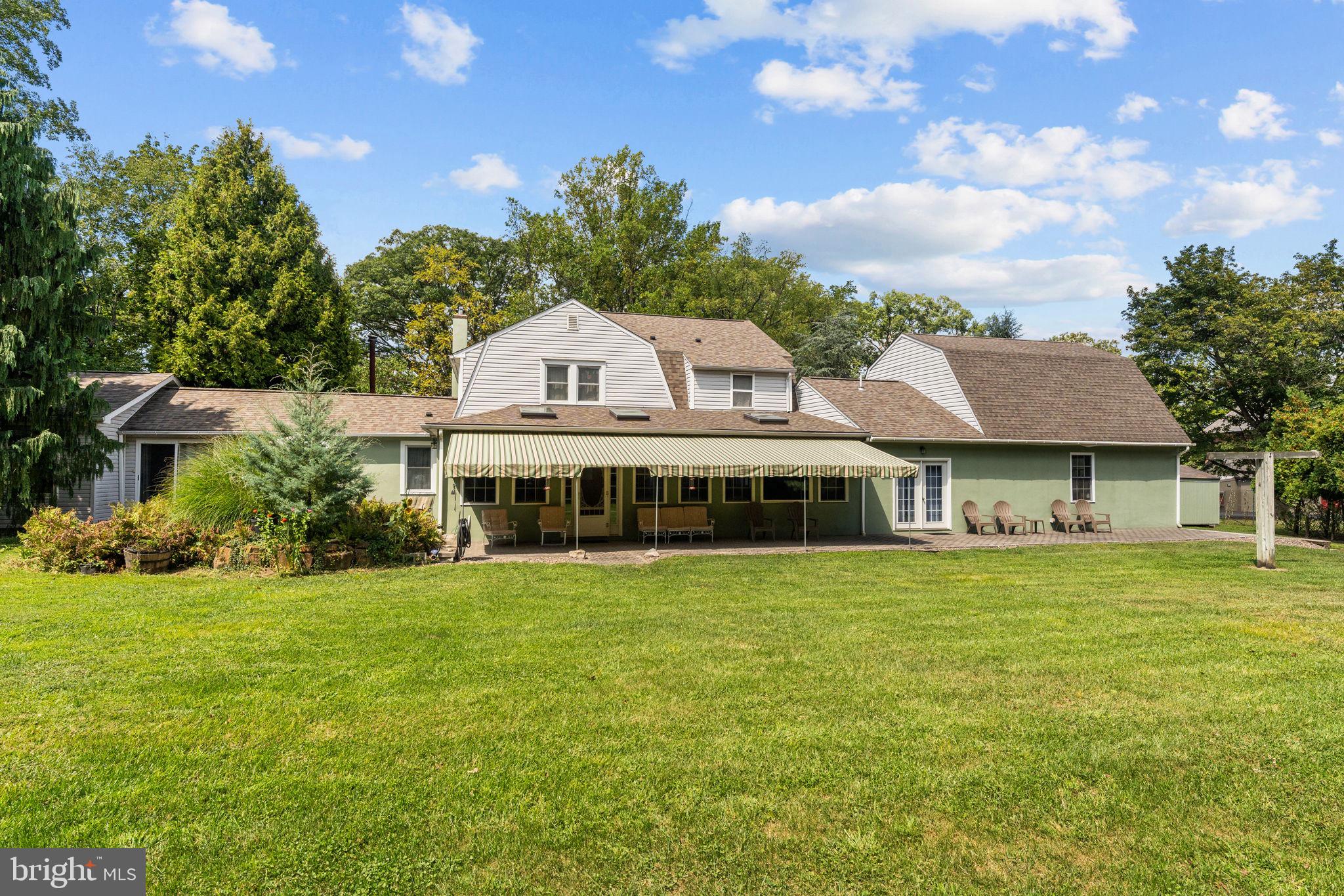 Welcome to a Unique Opportunity!
This Upper Dublin retreat presents a rare chance to own two complete residences in one extraordinary offering. Nestled on a private 1.2-acre setting within highly sought-after Upper Dublin Township and its award-winning school district, the property includes a charming 3-bedroom, 3-full bath, 2-story colonial residence paired with a 3-bedroom, 1.5-bath ranch guest house, ideal for extended family, in-laws, an au pair, or rental income. Blending character, comfort, and versatility, this serene retreat is truly one of a kind.
Arrive through the front driveway, framed by mature Atlas cedars, cypress, dogwood, and crape myrtle, with firebush that glows brilliantly each autumn. A spacious two-car garage connects seamlessly to a radiant-heated workshop and a family room with built in cabinetry, while there is also an additional one car garage for added convenience.
The main home showcases timeless craftsmanship enhanced by thoughtful updates, including a newer roof and a new HVAC system. At its heart, the kitchen features inlaid cherry cabinetry with inset doors, Corian countertops, a gas range, a double sink, and a beaded wood ceiling. Warm wooden ceilings and solid cinnamon maple floors extend throughout much of the main level, creating a rich, inviting atmosphere. Five Lazy Susan cabinets provide exceptional storage, while the adjoining dining and sitting area makes this kitchen the true hub of the home.
The family room, warmed by radiant heat, flows seamlessly into the bright, skylit sunroom. From here, step outside to the expansive 75-foot EP Henry patio, half shaded by a 35-foot awning. This outdoor showpiece overlooks a tranquil two-level pond with a cascading waterfall and stream, attracting birds, frogs, and wildlife to the natural setting. A half-acre of mature woods insulates the property in privacy, while a ring of evergreens encloses the spacious yard, making it ideal for both entertaining and quiet reflection.
Additional main-level highlights include a cozy living room with a wood-burning fireplace and maple flooring, a den and a full bath and convenient laundry closet.
Upstairs, two bedrooms and a versatile office/craft room share a full bath, while the spacious primary suite offers a private bath and an oversized dressing room with natural light. Attic storage spans the second floor, while additional storage is available over the double garage, in the basement, and within the outdoor sheds.
Year-round comfort is assured with central air, gas-heated radiators and baseboards, radiant floors, and even a wood-fired outdoor boiler as an alternate heating source. Generous closet space and tilt-in replacement windows throughout the home bring ample natural light and views of the landscape indoors.
The attached guest house/apartment offers independence and versatility with its own private paver patio near the pond. Inside, you’ll find three well-sized bedrooms, a full hall bath, a half bath in the primary bedroom, an open-concept kitchen and living area, and wood-grain vinyl flooring throughout the home. With its own washer/dryer and private entrance plus connecting entry via a buffer room, this apartment is ideal for extended family.
In addition to public water and sewer, the property is equipped with a private well—perfect for car washing and landscaping—offering both convenience and cost savings.
The location is equally appealing, just minutes from convenient local shopping centers, downtown Ambler’s shops, dining, movie theater, and playhouse, with Mondauk Park’s scenic walking trails nearby. Easy access to the PA Turnpike and train service into Center City ensures seamless commuting. With abundant parking, including space for an RV, this property is a rare opportunity for contractors, multi-generational households, or anyone seeking a private retreat with income potential.