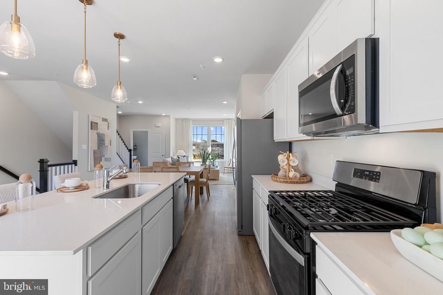 FULL BRICK FRONT MAY 2025 DELIVERY! This 3-story middle unit open and contemporary floorplan that encompasses 4 bedrooms, 3.5 baths, and a 2-car rear load garage is STUNNING, and ready for a new homeowner just in time for the summer. Thoughtful design and modern luxury are uniquely embodied in this townhome plan, which features 1,763 sq ft of living space. It offers a spacious main level eat-in kitchen with grey cabinets, recessed lighting, and a generous island providing plenty of cooking and entertaining space. The upper level boasts a private laundry closet and stylish primary bedroom, complete with a walk-in closet and dual vanities. The lower level features a finished 4th bedroom as well as a full bath. Hard surface flooring throughout the entire home (no carpet anywhere!) offer modern luxury and contemporary appeal.  With black windows and a black garage, the curb appeal of this home boasts an urban and modern feel that is sure to stand out.  This specific home also boasts clear sight lines directly in front and behind the home, providing an excellent view free of obstructions.  Location within the community is also IDEAL with multiple guest parking spaces directly behind the home, and easy access to mains roads leading in and out of the community.  Conveniently located across the street from tons of shopping and entertainment options. Incredible rates and closing incentive options available with the use of DHI Mortgage.