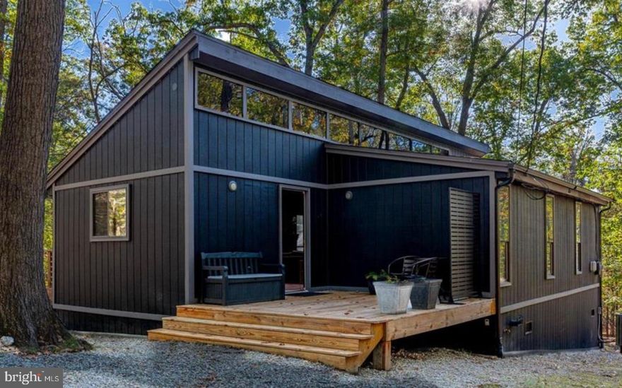 Morning coffee under the pines. Evenings by the fire pit or soaking under the stars. Welcome to 167 Onondaga Trail — a turnkey, fully re-imagined retreat privately tucked among the trees on a cul-de-sac street in the resort community of The Woods. Renovated from top to bottom, this 2-bedroom, 1-bath home blends a sleek modern design with rustic serenity.

Inside you’ll find vaulted ceilings with skylights, a wood-burning fireplace, upgraded flooring, and a luxury tiled bath with walk-in shower and dual vanity. The kitchen features subway-tile accents, a large island, upgraded countertops, and a gas-burner range. This home comes fully furnished, making it an ideal turnkey vacation home, income-producing rental, or full-time residence.

Set on a 1.07-acre wooded lot, the property offers multiple outdoor spaces including a front porch, rear deck, screened-in porch, hot tub, and fire pit. Enjoy The Woods amenities with the available Class B Membership: two golf courses (public play available), three pools, pickleball and tennis courts, a sports center with gym, and more. This is a rare opportunity to own a thoughtfully updated mountain-style getaway just minutes from Martinsburg and Berkeley Springs.
