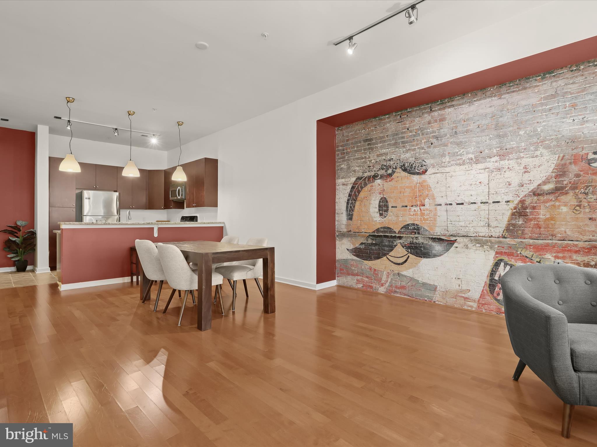 ***The Open House scheduled for 6/14 has been cancelled due to road work at the Charles Street Promenade, it will be rescheduled for a later date. We apologize for any inconvenience, but the roadways will be shut down. Contact the listing agent if you have questions.***
Welcome to this amazing, large, one-bedroom, one-bath home in the highly desirable secured entry, Twelve 09 condominium community, offering the convenience of single-level living with an urban vibe in an inviting setting. Step into the charm and uniqueness of this Baltimore condo, featuring a stunning focal point: an exposed brick wall adorned with a historic Natty Boh mural. This distinctive feature infuses the space with local character and a touch of nostalgia, creating a perfect blend of contemporary living and historic charm. The high ceilings and ceramic tile flooring guide you to the gourmet-inspired kitchen boasting stainless-steel appliances, granite counters, double sink with newer touchless faucet, pantry, and breakfast bar with pendant lighting. Step seamlessly onto the rich, engineered hardwood floor and experience the gracious openness of the sundrenched living area, presenting two alcoves perfect for placing a desk. Peaceful slumbers are assured in the expansive primary bedroom suite adorned with soft carpeting, double closets, and a dual-entry en suite bath highlighted by a ceramic tile surround tub shower. The convenience continues with the in-unit laundry area featuring a new, full-size washer and dryer, an exterior storage unit, a personal parking space in the garage, and a community fitness center. Stay close to nature in the private courtyard, where fresh air and greenery thrive. Indulge in the myriad attractions of this area, including the renowned Walters Art Museum, the iconic Washington Monument in the heart of Mount Vernon, and the area's captivating 19th-century architecture. With an array of dining options, cafes, and a plethora of shopping choices, the neighborhood presents a tapestry of experiences. Getting around is a breeze with close proximity to major routes such as I-83, I-395, and MD-Rt. 40. For alternative transportation, enjoy the convenience of the MARC Train, Amtrak services, and biking options. Don't wait—take the chance to make this remarkable, freshly painted gem your own, as it's sure to attract swift interest.