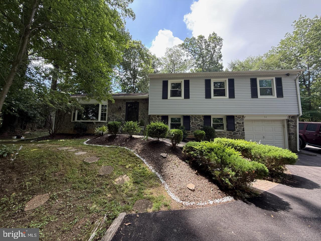 Move right into this lovely cared for home with beautiful and serene wooded views. Pull up on the newly paved driveway and walk up the gorgeous paver walkway. You'll note the beautiful stone and freshly painted home exterior. Enter into the main living room with oak floors and a large bay window. The kitchen is a cooks dream and the custom-built maple cabinets were recently refinished and painted. Notable features are the granite counter tops, tiled backsplash, and a wood grain porcelain tile floor. The stove and refrigerator are newer as well. From the kitchen, walk out to the paver patio with views of the beautiful yard and landscaping . The upper level main bedroom has a fully tiled en suite bath that includes a walk-in shower and granite top vanity. Walk out of the main bedroom through the French Doors to the peaceful expansive sunroom which leads to the rear deck. Beyond the deck there is a fenced in area with a stationary basketball hoop. There is storage shed in the back of the yard as well. Finishing the upper level is a fully tiled hall bath and 3 other nice sized bedrooms. The lower level includes a family room with gas fireplace, a half bath, laundry area and mudroom leading to the attached extended one car garage with electric opener. The home also has a newer water heater, ADT security system and LeafFilter gutter guards. Downtown Media, Linvilla Orchards, 95, 476, Train & Airport are conveniently accessible.