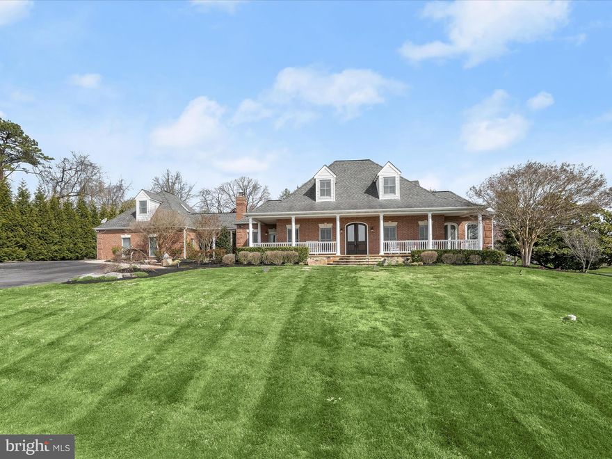 LUXURY ESTATE HOME AND FARMETTE

Presiding majestically over six rolling acres in the beautiful community of Bretton Woods in Gambrills, this fully renovated upscale farmhouse-style home invites luxury living and entertainment at every turn. Enjoy main level living in an open plan design that includes a gracious center stair flanked by a Family Room, Dining Room, a Gourmet Kitchen, Breakfast Room, Mudroom, Sunroom, and a Primary Bedroom and Bath Suite. Architectural integrity is artfully expressed with quality and authenticity inside and outside.

Outside, a stately gated entry and drive are lined with cherry blossoms that create a soft and welcoming canopy. Professional landscaping and hardscape design are enhanced with outdoor lighting and colorful blooms that together set the stage for exceptional outdoor amenities. A secondary entrance and breezeway unfold into the rear pavilion that protects an outdoor kitchen with sink, fridge, gas BBQ, and wok cook stations, media wall, stone bar, pergola, and dining patio. The expansive stone patio continues to a secondary sitting patio and fire pit before encircling the adjacent in-ground heated pool, spa, and waterfall in the rear. In the front of the house, a quintessential white four-board farm fence with “no-maintenance” vinyl-clad defines lush green fields with self-watering features, a six-stall barn with wash station, electric and water service, and a run-in shed.
Inside, a pair of richly finished double entry doors is shaped with a sweeping arch and embellished with leaded glass that is repeated in glass transoms over interior cased openings. The Sunroom and Breakfast rooms have vaulted ceilings, beams, and trusses made from locally sourced barn wood. The main level offers a primary bedroom and bath suite with a sitting area, private porch, two wardrobe closets, and laundry. Upstairs there are three bedrooms with hardwood floors, and a hall bath that is also a buddy bath shared by two en-suite bedrooms.

Downstairs, a fully finished lower level emerges with a gracious, wide, and cascading stair. Rooms that encircle the stair include a home office with a built-in desk, library shelves, and cabinetry, a Guest Quarters for sleeping, and a Full bath. The Guest Suite and bath are conveniently located adjacent to the Kitchenette.  A generous Recreation/Theater space with recliners and movie screen are sided by a Fireside Sitting Area with a gas fireplace, and a Billiards Table behind it.  The breezeway links the main house to a conditioned, three car garage, a secondary powder bath, and another gathering venue in the carriage house above the garage. Elevate the vibe on game day in a space outfitted with a variety of game machines, wall mounted media, sound system, wet bar and full back bar.
Bring your equestrian treasures and come home to luxury in this one-of-a-kind estate home and farmette!