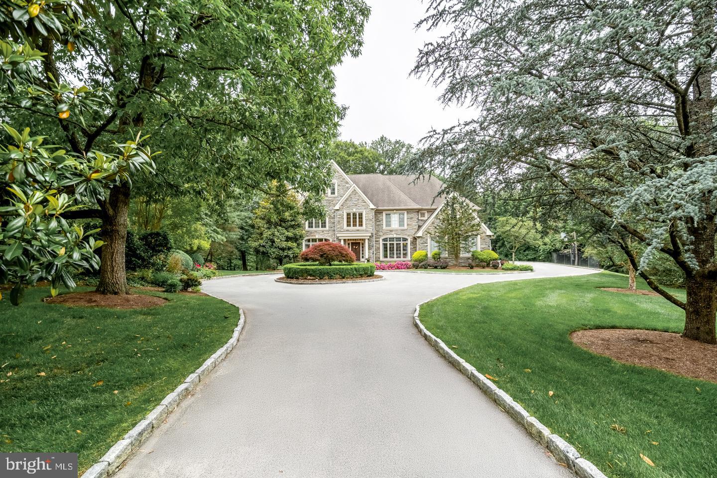 Discreetly tucked away, at the end of a private lane in Bryn Mawr's most prestigious estate section, is
841 Colony Court. This custom-built home showcases the finest in luxury living, prime location, and sophisticated lifestyle. This residence is set on 1.5 of lush, manicured acres, showcasing mature landscaping and rare perennial plantings. You will be overwhelmed when you approach the home from the impressive circular driveway and see the impressive stone facade. No detail has been overlooked in this residence that has been impeccably upgraded both inside and out. The gracious foyer makes an elegant impression with a stately staircase rising to an open landing. Soaring ceilings, extensive custom millwork, designer finishes and finished on site hardwoods are throughout the main level. True to the classic center hall floor plan, the spacious dining room with a picture window is on the right of the foyer and the formal living room with fireplace is located to the left and a powder bath is located discreetly tucked away here as well. Glass-paneled wood doors in the living room open to an impressive, wainscoted office complete with custom bookcases. A wet bar/butler's pantry connects the dining room & chef's quarters for easy serving when hosting guests. The ultimate gathering spot is the stunningly renovated kitchen, centered by a huge island with generous seating. Custom cabinetry, a La Cornue range/oven, Wolf wall and steam ovens, 48" Sub-Zero refrigerator & custom walk-in butler's pantry enhance the heart of the home. Enjoy casual meals in the open breakfast room, step out sliding glass doors to the large deck for outdoor dining and entertaining, or relax in the family room with a fireplace flanked by built-ins to watch TV or movies. Rear stairs, a mudroom, garage access and a second powder room sit conveniently by the kitchen. The 2nd story covered in plush, high-quality carpeting presents a magnificent primary suite with a vaulted ceiling in the bedroom, spacious sitting room and 2 custom-fitted walk-in closets. Your new luxurious spa bath is styled with custom cabinetry, dual sinks, freestanding tub and oversized shower. Three more-bedroom suites offer generous closets with custom built-ins and en-suite baths. Additionally, there is a 2nd office and laundry room, both with built-ins as well. The finished basement is perfect for recreation with a family/media room, open billiards/game area, gym and another full bath. DO NOT miss this stunning home.