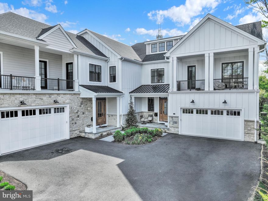 Set along one of the most coveted stretches of Main Street in New Hope, this exceptional Riverwalk residence represents a refined expression of luxury living, where sophisticated design, elevated finishes, and an extraordinary walkable setting converge seamlessly. Built just four years ago by Barley Custom Homes, the home showcases impeccable craftsmanship and thoughtfully curated interiors across nearly 3,600 square feet.
A welcoming front porch offers a graceful introduction before opening into a light-filled interior defined by soaring 10-foot ceilings and a dramatic foyer. Designed with both elegance and livability in mind, the main level unfolds effortlessly, anchored by a stunning great room with fireplace and walls of tall glass doors that flood the space with natural light while creating a seamless connection between indoors and out. The great room flows seamlessly into the chef’s kitchen, complete with Wolf  Sub-Zero appliances, a six burner range, a generous walk-in pantry, and spaces tailored for elevated entertaining and everyday ease. A private office, thoughtfully designed mudroom with abundant storage, and attached two-car garage further enhance the home’s functionality without compromising design.
Perfectly positioned along the towpath with the Delaware River just across the street, the setting offers a rare balance of privacy and connection. Enjoy effortless walkability to the acclaimed restaurants, boutiques, galleries, and vibrant cultural energy that define New Hope, while the charming river town of Lambertville is just moments away. Here, daily life is immersed in the beauty and rhythm of one of the region’s most sought-after destinations.
The second level features four beautifully appointed bedrooms, each complemented by their own ensuite bath, offering both comfort and privacy throughout. One bedroom opens directly to a private balcony, creating a quiet retreat overlooking the surrounding landscape. The primary suite is a sophisticated sanctuary, featuring a spa-inspired bath with an oversized glass shower, dual vanities, and a sleek, modern aesthetic designed with understated luxury in mind. A well-positioned second-floor laundry room and airy loft space further elevate the home’s thoughtful design and livability.
An elevator services all floors, leading to a third-floor loft and flex space complete with a full bath, ideal for a guest retreat, lounge, playroom, or additional living area, along with generous storage integrated throughout.
Outdoor living is equally compelling, with a private deck overlooking the towpath and a setting that effortlessly blends nature, luxury, and walkable Main Street living.
This is more than a home, it is a rare lifestyle offering in one of Bucks County’s most iconic river towns, where timeless architecture, effortless luxury, and an unparalleled location come together in a way that must be experienced to be fully appreciated.