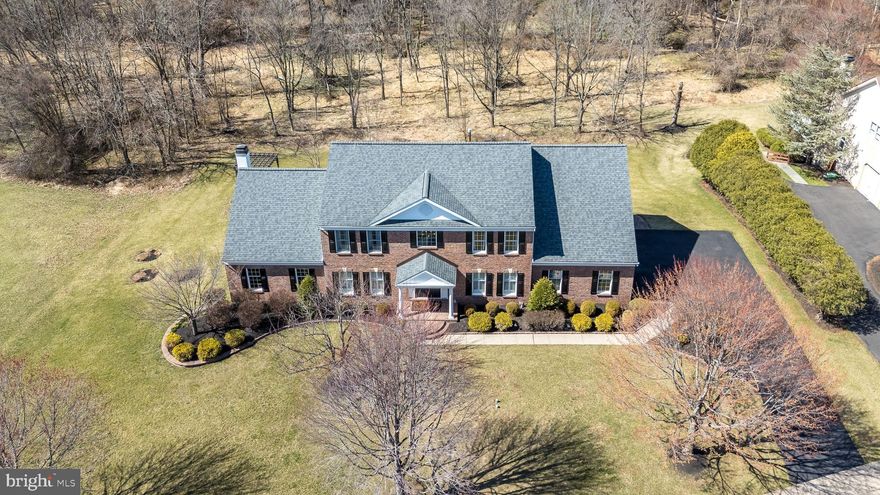 Welcome to the market for the first time this expanded and updated Toll Brothers Mercer model home in the desirable Bridle Estates community of Lower Makefield Township, Yardley, offering luxury and privacy on a premium lot surrounded by preserved space. Featuring a grand two-story foyer with custom inlay wood floors, a curved stairway, and fine millwork, the home boasts a formal living room, spacious dining room, and an updated kitchen with high-end finishes. The kitchen opens to a family room with a cathedral ceiling, gas fireplace, and access to a study. The main floor also includes an updated powder room, laundry room, and a three-car garage. A maintenance-free deck off the breakfast room provides scenic wooded views. 
Upstairs, the main suite features cathedral ceilings, a sitting room, an updated spa-like bath, and a walk-in closet, alongside three additional bedrooms and an updated hall bath. The finished lower level includes a media area, custom bar, stone fireplace, game area, full bath, and storage. Walkout access leads to additional outdoor living space featuring paver patio with a custom outdoor kitchen, fireplace, pergola, and hot tub.
Located in award winning Pennsbury School District and conveniently situated to major highways, transit, airports, hospitals, dining, and shopping. Best and final OFFER DEADLINE TODAY 6PM Sunday March 30 2025