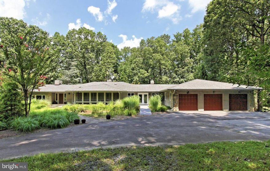 Modern contemporary on 5 private acres with cedar and local Carderock stone construction, heated pool.  Two-story windows for light-filled spaces throughout.  Quality finishes with hardwood floors stone accent walls, tiered interesting spaces.  Two bedrooms on the main level with two full baths.  Primary bedroom with dual walk-in closets, spacious primary bath, French doors that lead outside.  Sunken family room with full-surround stone fireplace and wall of windows with panoramic views of the backyard. Sunroom addition with full windows and cathedral ceiling.  Three car garage that leads to the mudroom with separate entrance.  Finished lower level with another two bedrooms and one full bath, recreation space and den with walkout to the pool.  Amazing outdoor space with tiered stone patio, waterfall and pool.  Enjoy the wildlife and privacy of this rare lot.  Easily entertain hundreds or host small family gatherings.  Located minutes to Tysons Corner, Rt. 7 and major commuter routes.