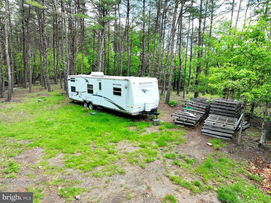 Escape to the mountains of West Virginia and discover the haven you've been yearning for. Embrace the chance to bring your off-grid dreams to life, as this property boasts a drilled well and a newly improved driveway leading to an elevated building site, complete with a Rockwood camper ready for weekend getaways. The camper, included in the price, accompanies the property, providing instant access to your mountain oasis. This pioneer-ready property spans 20 acres, embraced by dense pines and scattered hardwoods, promising privacy and seclusion. With its expansive landscape and varied terrain, this land presents an ideal setting for your recreational getaway. Experience the abundance of wildlife that surrounds you, with Deer, Turkey, and Bear. An existing power line right-of-way serves as a convenient pathway for hunting, shooting, or exploration on an ATV. While power is currently unavailable on the property, the future arrival of power infrastructure will only enhance its value. Secure this steal of a deal today and start planning for the future. Don't miss out—call now to schedule a showing!