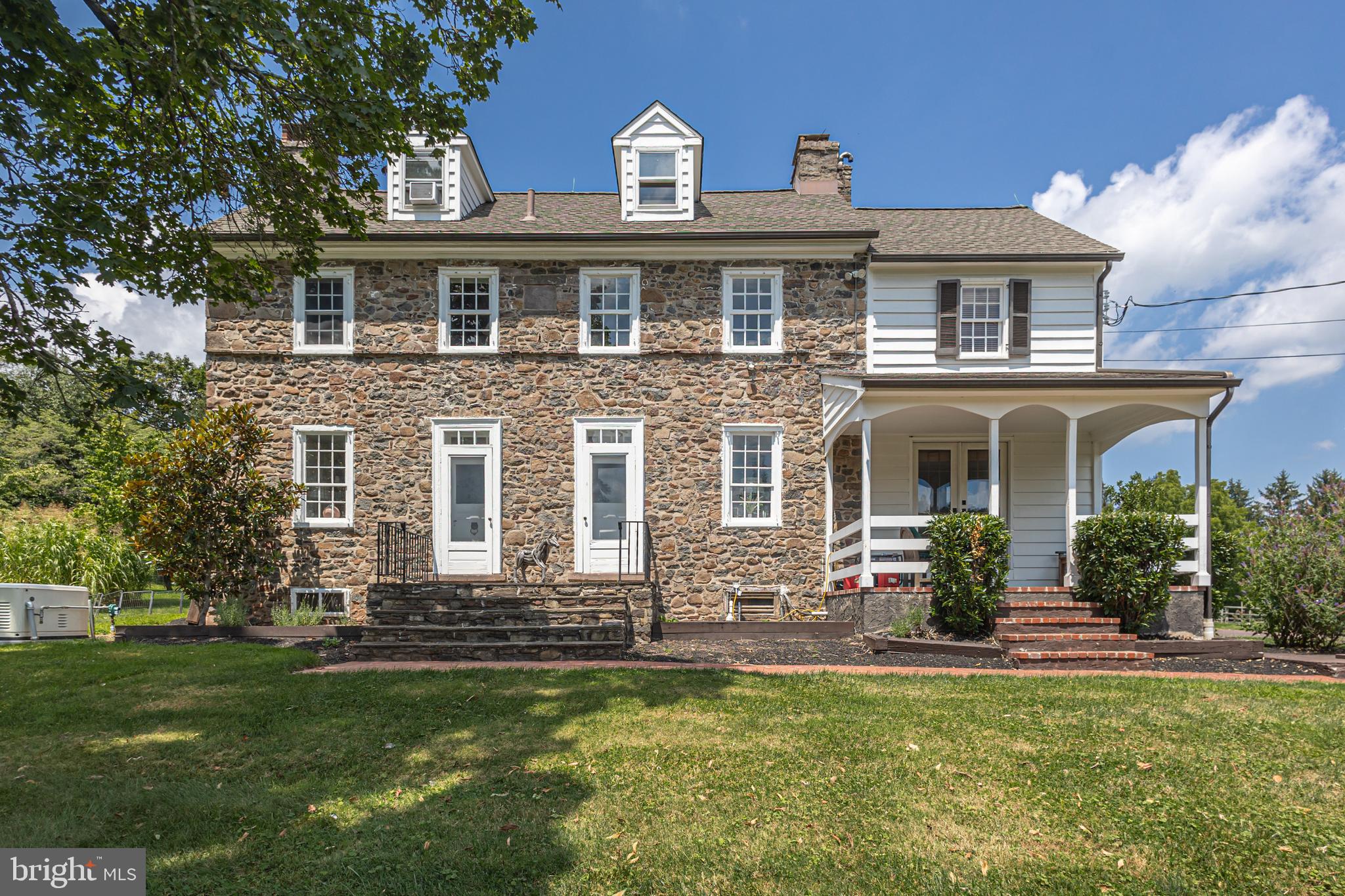 Flower Farm offers a rare blend of history and charm on a 5.25 acre parcel in picturesque Upper Makefield Township. At its heart lies a distinguished 1795 stone farmhouse, gracefully complemented by a separate in-law/guest cottage, and equestrian potential with a five-stall horse barn. The main residence showcases wood flooring throughout the first level, where timeless elegance meets everyday functionality. A formal living room and family room, each with their own fireplace, flank the foyer. The formal dining room—perfect for entertaining—features exposed stone walls and French doors that open to a brick floored screened porch perfect for enjoying informal family gatherings or a morning cup of coffee. The spacious kitchen with its stainless steel appliances , newly installed granite countertops and thoughtfully designed layout invite intimate gatherings. Also, on the first floor is a flex room (study or bedroom) along with a full bath. Upstairs, the second floor offers a serene primary suite, two additional bedrooms, additional space for a home office and a walk-up third floor attic, ready for thoughtful updates. Step outside onto a covered porch, breezeway, and vine-draped pergola, that seamlessly connects to the adjacent guest cottage. This charming in-law/guest cottage boasts its own eat-in kitchen, cozy living room with fireplace, first-floor bedroom and full bath, and hardwood floors throughout. The second level provides a private suite complete with a full bath and walk-in closet. Perfectly suited for a multi-generational family compound or weekend retreat, this charming property offers peace and privacy, yet remains just 90 minutes from New York City, 50 minutes from Philadelphia, and 30 minutes from Princeton.