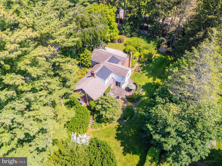 Set on a generous and level 0.89-acre lot in one of Radnor Township’s most desirable neighborhoods, this rare opportunity offers unlimited potential for renovation, expansion, or brand-new construction. Surrounded by established estate homes and located within the award-winning Radnor School District, the setting alone makes this a compelling offering for both homeowners and builders.

This home’s position—on the highest elevation along Parkes Run Lane—enhances its privacy, natural light, and separation from surrounding properties. The existing stone and brick multi-level Cape features 4 bedrooms, 3 full and 2 half baths, and a flexible floor plan with distinctive architectural elements. The living room is highlighted by a vaulted ceiling, custom built-ins, and a fireplace. The formal dining room opens to the rear patio through sliding glass doors, as does the adjacent kitchen, which includes a breakfast area and a large walk-in pantry. A powder room is located just off the foyer.

A few steps from the kitchen is a spacious family room with another fireplace, built-ins, and wet bar—plus interior access to the two-car garage and an adjoining solarium with greenhouse-style windows. Below that, a partially finished lower level offers an office, half bath, laundry area, and ample storage.

Optimally located near top-ranked schools, the train, and downtown Wayne, this property offers the flexibility to reimagine the existing home or create a custom new residence from the ground up—all in a quiet, elevated position within one of the Main Line’s most prestigious neighborhoods.