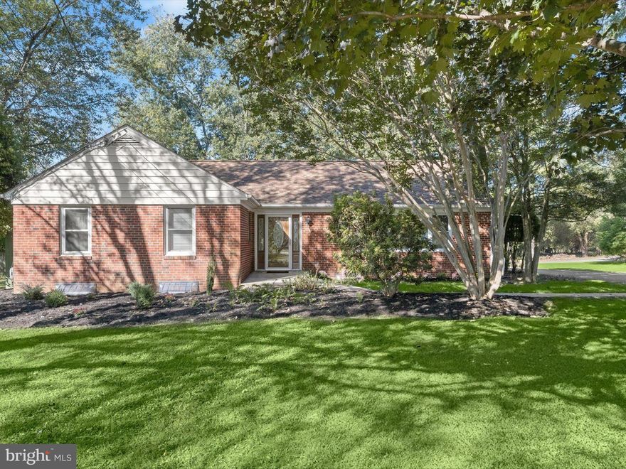 This beautifully renovated brick ranch home in Woodstock blends timeless character with modern comfort and exceptional outdoor spaces. Mature trees, a tranquil pond, and lush landscaping frame the property, which also features a barn with electric, a detached garage, and dual driveways for added convenience.
Inside, the home showcases fresh paint, refinished hardwood floors, new carpet, and updated lighting throughout. To the right of the foyer, a spacious living room features a wood stove insert and a stunning picture window that fills the space with natural light. The adjoining dining room includes two built-in corner cabinets and connects to the renovated kitchen, complete with inset cabinetry, granite counters, and stainless steel appliances including a double oven.
The expansive three-season sunroom is a true highlight, offering a cathedral ceiling, corner wood-burning stove, and walls of windows overlooking the property. Recently redone with new tile flooring, updated exterior siding, and a peaked roof, it creates a seamless connection between the home and the surrounding landscape.
The main level includes three bedrooms, among them a primary suite with an en suite bath featuring a tiled soaking tub and shower surround. Two additional bedrooms share another full bath with a frameless glass shower. Both full baths are enhanced with heated floors for added comfort. 
The finished lower level extends the living space with a large recreation room featuring a wet bar and full-length bar seating, a bonus room, and a half bath for flexibility. The utility room provides laundry, storage, and a separate entrance from the sunroom. A walk-up attic provides additional storage space, offering even more functionality to the home.
Set on 1.39 acres across two parcels, a 1.03-acre main lot and an additional .36-acre parcel referenced on the deed, this property offers room to spread out and enjoy the natural setting. Outdoor living shines with multiple paver patios, a fire pit, a pond accented by a bridge leading to a lower patio, and mature landscaping that provides privacy and tranquility. A flourishing garden and berry patch add to the appeal, creating a space where you can cultivate and enjoy your own fresh harvest right at home.
The detached garage accommodates four or more vehicles and is currently being used as an exercise room, while the barn provides additional storage and workspace with electric, lighting, and fans.
Ideally situated, this property captures the best of peaceful, semi-rural living with convenient access to nearby outdoor recreation at the Howard County Conservancy and Patapsco Valley State Park. Everyday amenities and commuter routes including I-70, Route 40, and Route 29 are just minutes away, making this Woodstock residence a rare combination of serenity, function, and modern style.