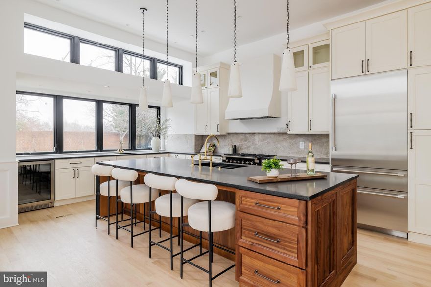 Once home to Washington’s iconic Hoagie House, 304 N Street NW has been reintroduced as a thoughtfully designed new construction residence within a boutique six-home development. Integrating the property’s historic context within a contemporary design, the residence is a poster child for sophisticated urban living, offering a refined four-level lifestyle defined by curated materials, thoughtful design, and modern functionality. Executed by an award-winning builder—recognized as an eight-time Contractor of the Year by the National Association of the Remodeling Industry, recipient of Historic Restoration of the Year, and a Chrysalis Award winner, with features in Remodeling Magazine and on the cover of The Tile Shop—this home reflects an exceptional standard of craftsmanship and design integrity.

An ethereal end unit with ample exposure to natural light, the home’s pale brick exterior accented with dark trim paints a curb appeal exuding restrained elegance. Entry into the fully open concept main level is distinguished by towering 11-foot ceilings, wide-plank oak flooring, and motorized window treatments. A generous 2,950 square feet of living space is spread across all levels, finished in a tastefully luxurious palette. The free flowing living and dining areas are anchored by a fireplace finished in Nero Marquina marble, which continues through the built-in surfaces for a cohesive architectural statement. At the heart of the space is the kitchen, painstakingly designed as a practical daily area and a bold statement of design prowess. Featuring a walnut island, Taj Mahal quartzite surfaces, custom cabinetry, a full Thermador and Bosch appliance package, and an AGA range, it is the culinary enthusiast’s dream. The upper levels are dedicated to private living spaces. The primary suite is arranged as a quiet retreat, with a luxury hotel-inspired bath showcasing a freestanding soaking tub, walk-in shower, slate herringbone mosaic floors accented by brass and bronze fixtures, and a floating walnut double vanity. Dual walk-in closets with custom built-ins complete the suite. Secondary bedrooms are well-proportioned and feature custom closet systems and en-suite baths. The fully finished lower level offers flexibility for a variety of uses, including guest accommodations or income potential. It includes a bedroom with en-suite bath, a dedicated laundry room, a mini-bar, and a private walk-up entrance that enables total self-sufficiency. The rooftop level serves as an extension of the living space and is accessed via a motorized retractable skylight. The terrace is outfitted with porcelain pavers, an outdoor kitchen, and a brick fireplace, creating a functional outdoor environment suitable for year-round al fresco entertainment. Additional features include a private EV-ready parking space, LG Styler steam closet, dual laundry areas, and designer lighting and finishes throughout. Situated in one of Washington’s most vibrant neighborhoods, 304 N Street NW presents a rare opportunity to own a modern residence rooted in the city’s historical past while setting new standards for the urban lifestyle.