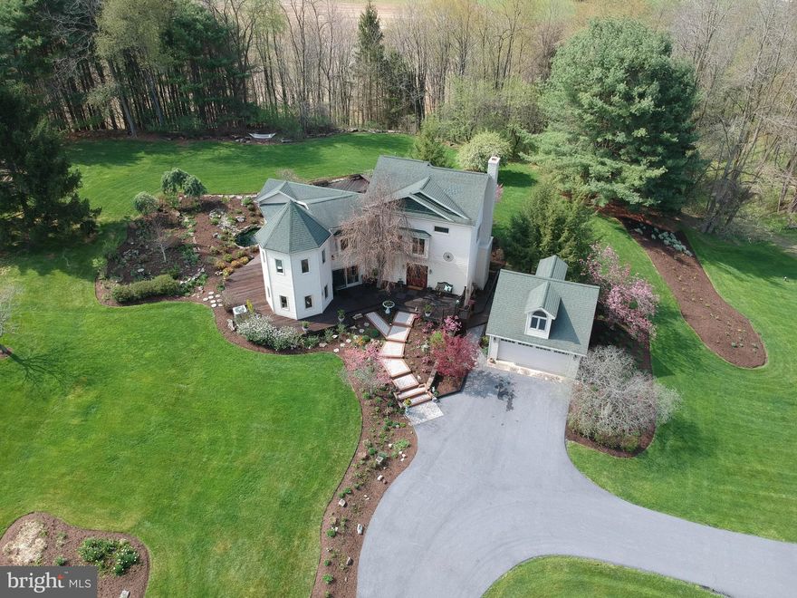 Enjoy this gorgeous 5 bedroom, 3.5 bath home, perfectly situated in the desirable Pantops Neighborhood on an unprecedented 5-acre lot! As you approach the property, a private driveway leads you to a stunning, unique home, surrounded by lush, meticulously curated landscaping that sets the stage for what lies ahead. The expansive wraparound deck invites you to immerse yourself in the serene beauty of flower beds, tranquil ponds, and ornamental trees, creating an idyllic outdoor space for both relaxation and entertaining.

Inside, the home unfolds with sophistication and elegance, featuring soaring windows in the living room that provide natural light, and windows throughout that offer breathtaking views of the picturesque grounds from nearly every room. The formal dining room seamlessly flows into the heart of the home—the impeccably remodeled kitchen. Custom Amish-built cherry cabinetry, gleaming granite countertops, double ovens, and high-end stainless steel appliances make this a chef’s dream, while the abundance of natural light creates a warm, inviting atmosphere.

The primary suite is a sanctuary, offering an extension with 6-sides of natural light and soaring cathedral ceilings that amplify the sense of space. This home also boasts an impressive array of updates that include a new bathroom, new windows, bamboo flooring and new lighting throughout the home, and an energy-efficient heat pump system to ensure year-round comfort. The property is complemented by a spacious 2-car garage, as well as a 1,000-square-foot workshop, perfect for any project or hobby, offering endless possibilities for creativity and storage.

Set within the State College Area School District, this remarkable property offers the perfect blend of privacy and convenience. Whether you’re seeking a tranquil retreat or a home that offers splendor, space, and comfort, this property truly has it all. With its unique features, exceptional upgrades, and unmatched privacy, this is a rare opportunity you don’t want to miss.