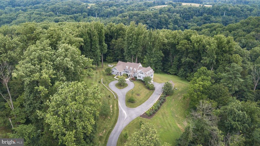 Must see custom built home with almost 6,200 total sq ft on a prime 9 acre wooded lot near Historic Ellicott City. This is a "once in a lifetime" type of home for the discerning buyer who values quality construction on a serene and private lot. Endless upgrades include: Pella Impervia fiberglass casement windows; cementitious siding over 3/4" rain screen w/ Azek trim boards; 2'x6' framing exterior walls w/dense-pack cellulose insulation and 2" Roxul continuous exterior insulation board; 4" rigid insulation under ground floor concrete slab; 2-60 gallon hybrid heat pump water heaters; 5 separate HVAC zones; 20kw propane fueled Generac generator w/fully automatic transfer switch; 500 gallon in-ground propane tank; whole-house energy recovery ventilation system for fresh air and exhaust; water softener and whole house water filter; fire sprinkler system; tile floors in kitchen and all bathrooms; solid core 5-panel doors; custom trim and crown molding throughout main rooms. A stunning floor plan features: gleaming hardwood floors; arched openings; chef's dream kitchen w/commercial grade 48" gas Viking range top w/4 large burners, griddle and grill, range hood w/automatic damper for make-up air, double wall oven, convection microwave, warming drawer, separate under counter ice-machine, undercounter refrigerator, large single stainless steel sink plus large bar sink in island, custom cabinets, granite tops, walk-in pantry w/built-in shelving, mudroom, office w/built-in shelving; formal dining room; living room w/gas fireplace and French doors to deck; main level powder room and laundry room w/front loading washer, dryer, utility sink and built-in shelving; 1st floor bedroom or "nanny or in-law suite" w/walk-in closet w/built-in shelving and en suite full bathroom; upper level w/3 bedrooms and 2 full bathrooms; owner's bedroom w/tall 12' ceilings and huge walk-in closet; owners' bedroom w/en suite full bathroom w/double sinks, cherry cabinets and tiled walk-in shower; bonus storage closets and walk-in attic access which could be finished for future sq ft; fully finished lower level w/walk-out and full size windows featuring a large rec room w/cork flooring and wet bar, 5th bedroom, 4th full bathroom, bonus office, 2 storage/utility rooms and access to oversized 2.5 car garage; large, detached garden shed w/overhead door; relax on the covered patio, deck, screened in porch or the the secluded patio with wood burning firepit. An amazing lot w/tranquil views and circular driveway. Zoned for premier Ellicott City schools and minutes to Historic Ellicott City shops, restaurants and entertainment. Don't miss out on this amazing opportunity.