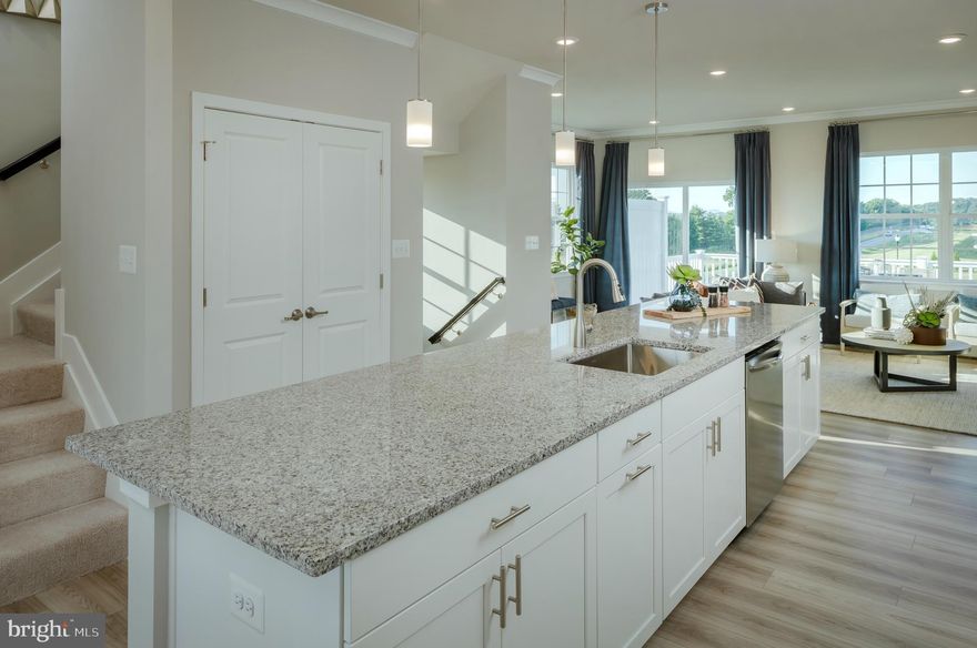 November MOVE-IN ! New luxury 3 level townhome located in Chapelgate, Lennar Homes newest Howard County community, offers the promise of comfort and style. The first floor features, storage area, a rec room, a full bath, perfect for family and guests.  The main living level has the mid kitchen with staggered height, white, soft close cabinets and an expansive center island.  Designer Select package with Frigidaire Gallery stainless appliances include, 5 burner cooktop, range hood, French Door refrigerator with built in water and ice, and a hidden controls dishwasher.  The Iced White quartz counters provide durability and lasting beauty.  Your kitchen island provides seating space for 6 or more and overlooks the family room and dining room.  From the family room enjoy your deck with stairs to your yard that backs to an open park setting.  Your deck has space for grilling, relaxing with family and friends or a good book and provides an ideal set-up for modern living.  Upstairs caters to intimate spaces with laundry area, two secondary bedrooms and a full tiled bath.  The private owner’s suite is complemented by a full-sized bathroom with an Iced White quartz topped double vanity and a spacious shower with a seat and frameless door. Window blinds included.  A driveway and one car garage provide parking and storage. Prices and features may vary and are subject to change without notice.  Conveniently located to the shops and restaurants at Turf Valley, I70, 29, Baltimore, Washington DC and everything in between. Photos are for illustrative purposes only.