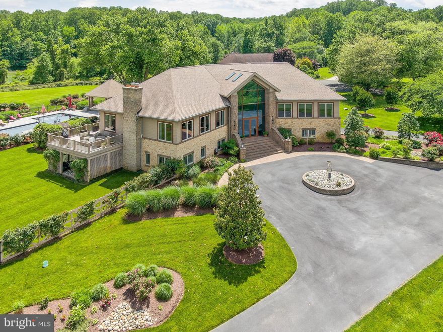 Welcome to 6975 Kim Lane, a stunning home set in the esteemed Chesapeake Overlook community. This community features a private beach and is just minutes to the award-winning Herrington Harbour South Marina. Offering an unparalleled blend of luxury and coastal charm, this property boasts panoramic views of the Chesapeake Bay and offers an exceptional blend of luxury and charm - a true testament to meticulous design and thoughtful craftsmanship. As you enter through the custom-imported German front door, you’re greeted by a grand foyer adorned with a stunning custom chandelier. A split staircase ahead leads to an inviting sitting area filled with natural light, offering a warm welcome into the home’s refined elegance. Ten-foot ceilings with intricate crown molding and gleaming Italian ceramic tile floors create a sense of openness and sophistication throughout this home. The gourmet kitchen with custom cabinets and exotic granite countertops is a showstopper. Anchored by a large island with seating for four and equipped with Viking Professional appliances (a 6-burner gas cooktop with griddle, built-in refrigerator and freezer, steamer, double ovens, pot filler, trash compactor, a second sink, and separate ice maker), you'll notice that no detail has been spared in the design of this area. A butler’s pantry adds even more function with a beverage cooler, sink, and abundant cabinetry. The formal dining room features a custom granite dining table ideal for gatherings of any size. The spacious, grand living room features a gas fireplace, custom built-ins, and expansive windows that flood this space with natural light and showcase stunning water views. Sliding doors lead to the deck—perfect for unwinding or hosting with the Bay as your backdrop. This main level also features a spacious primary suite designed for comfort and indulgence, complete with a private sitting area overlooking the Bay, two walk-in closets and a spa-inspired bath with heated floors, dual vanities, a jetted soaking tub and a large walk-in shower. A second bedroom on this level also includes a walk-in closet and private en-suite bath, ideal for guests or family. The lower level offers a seamless blend of function and luxury. From the oversized two-car garage with abundant storage, step directly into a spectacular wine cellar and cigar lounge—perfect for relaxing or entertaining with style. This level also includes two private offices, both with access to the stone patio and garden, a large third bedroom with a spacious closet, the laundry room and a versatile room that can serve as a 4th bedroom or a home gym, complete with a sauna. The large recreation room features a second fireplace, a full wet bar with seating, and sliding doors leading to the meticulously landscaped grounds. The fully fenced backyard is a private resort featuring a heated pool, a flagstone patio, gazebo and a full outdoor kitchen with a TV and dining area. Raised garden beds, a basketball area, and lush landscaping with an irrigation system provide both