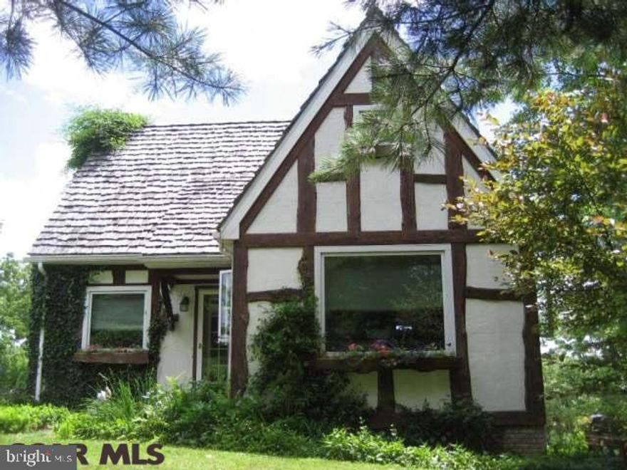 This property has a private 8.3 acre setting with wonderful views, a well built Tudor style home, a 40x24 barn converted to workshop and much more. The owner-built custom home features stucco board with wood trim and brick exterior, hand split wood shingles, and a gracious deck area. The interior has wood flooring, two propane fireplaces, a walk out basement, large bedrooms, views from every window, and features throughout the house to discover and enjoy like the pine wainscotting, 4 panel wood doors, custom kitchen cabinets, and Tiffany-style light fixtures. The family room is set up to also use as a bedroom with large closet and a full bath on lower level. The land can also be subdivided up to two additional lots. Call to set your showing appointment today!