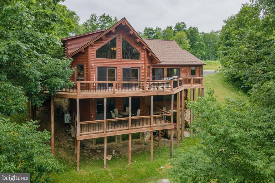 Luxury Log Home Perched atop Wisp Mountain – This 6 Bed, 5 Bath chalet offers 4227 sq ft, and features three stories of outdoor living space, vaulted ceilings, timber accents, and lots of glass to let in the mountain/lake views! Modern kitchen with stone tops and stainless appliances. Rugged stacked stone fireplace in the great room with a second fireplace on the lower level. Fully finished walkout basement with additional living and game room. So much room for activities… including taking a swim in your very own indoor pool! Two levels of sprawling outdoor decking tucked away on over 3 acres of private wooded land. An established vacation rental, “Splash Mountain” would make a perfect private getaway with excellent rental potential. Sold “turn-key”, fully furnished,  just minutes from local establishments, Lodestone Golf Course, Wisp Resort, and Deep Creek Lake – this mountain retreat has easy access to everything the area’s got to offer. Call today for details!