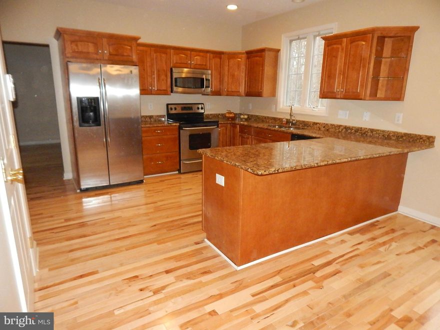 Newly installed maple hardwood floors in living room, family room, dining room, hallway, foyer and first level half bath. Freshly painted. Enormous first floor family room w/wood burning fireplace & vaulted ceiling, adjoining custom kitchen w/stainless steel appliances, granite counter tops & soft close cabinets. Absolute move in condition with new wall to wall carpets. Private, backing to woods.