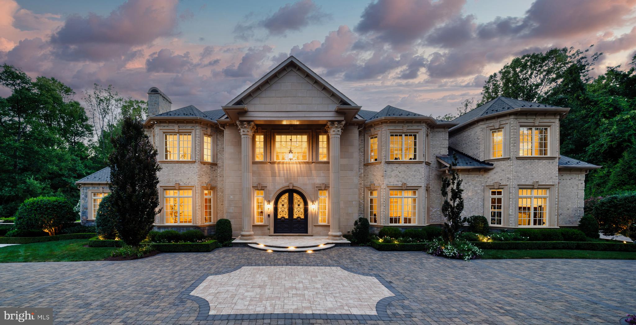 A lavish blend of old-world elegance and modern convenience, 1174 Old Tolson Mill Road epitomizes luxury estate living. Nestled on a private road in prestigious, wooded McLean, this grand home is set behind motorized wrought-iron gates. Its exterior, crafted from brick and stacked stone, exudes timeless refinement, further enhanced by a paver driveway and new landscaping by Charles Owen.
The double-height portico, supported by Corinthian columns, welcomes you to opulently curved wood and glass double doors with intricate wrought iron inlays. These doors open to a grand foyer featuring a mezzanine and a bifurcated central staircase inspired by New York’s Four Seasons Hotel. Marble floors, thick moldings, and wrought iron railings set the tone for over 15,000 square feet of meticulously designed living space by Arlene Christos.
The main level boasts 12.5-foot ceilings, soaring to 24.5 feet in the great room, which features a floor-to-ceiling fireplace. The great room also includes hidden invisible speakers, adding to the atmosphere without sacrificing the classic design. Formal living and dining rooms, adorned with masterful millwork, flank the grand reception hall. A wood and cloth paneled library overlooks the rear lawn, and a main floor suite offers multigenerational flexibility with a walk-in closet and a spa bath.
The kitchen is a chef’s dream, equipped with two islands, furniture-grade cabinetry, and high-end Miele, Sub-Zero, and Wolf appliances. Adjacent to the kitchen is a cozy family room with a gas fireplace, terrace access, and a high-end Meridian surround sound system offering a movie theater-like experience. The home’s advanced Crestron system controls music, cameras, blinds, and lights, all accessible via smartphone app.
The upper level features a resplendent primary suite spanning over 38 feet, with a double-tiered tray ceiling, an automated Phantom screened-in balcony, a hot tub, and a spa-inspired bath clad in travertine. Three additional bedrooms, each with ensuite baths and walk-in closets, offer luxurious accommodations. Automated blackout shades, a large laundry room with two sets of appliances complete this floor.
The lower level, designed for entertaining, includes a recreation room with a masonry fireplace, a central wet bar flanked by twin wine cellars, a game room, a professional home cinema, and a wellness center with a steam shower and sauna. A generous bedroom suite completes the walkout lower level.
The estate features comprehensive security and smart home systems, including 18 outdoor/indoor security cameras, customizable display cameras with sound, and 21 days of recording covering the kitchen, garage, gate, and door. Cell phone boosters are installed on every level. Windows and doors are hardwired to the alarm system for enhanced security. Over $350k has been invested in these systems, ensuring both luxury and peace of mind.
Outside, the rear terrace overlooks two acres of private, fully-fenced grounds, featuring a large patio and winding pathways. Behind the scenes, commercial-grade systems include a private elevator serving all three levels, dual garage lifts for five-car parking, four HVAC systems, a central vacuum, and an 80,000-kilowatt Generac generator.
1174 Old Tolson has secured approved permits from Fairfax County for a resort-style pool and a home addition on the lower level, seamlessly extending adjacent to the pool area. The renderings in the gallery showcase these approved plans.
With fortress-like construction, unparalleled craftsmanship, and a discreet yet convenient location, 1174 Old Tolson Mill Road epitomizes refined living, offering an unparalleled sanctuary for those who seek the utmost in elegance and exclusivity.