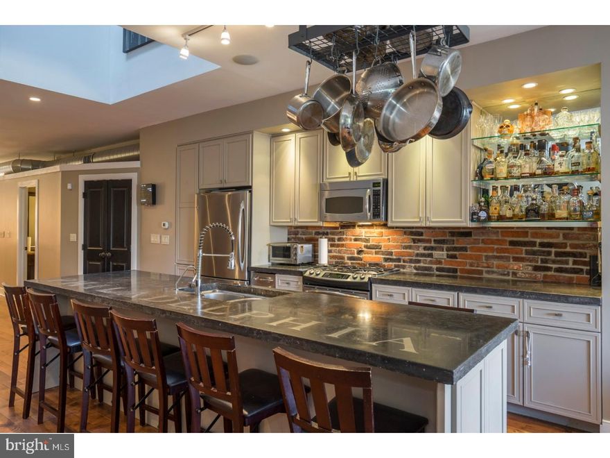 If you crave owning a home like no other, then 445 Poplar Street is the place for you. Its custom design details and originality earned it a write-up in Philadelphia Magazine. Originally crafted by a builder for his own personal use, this rare gem provides a perfect blend of impressive craftsmanship with dramatic architectural details. With its expansive open layout, the main floor is an entertainer's dream. At either end are bright and sunny living areas, with one side being used as a playroom and the other as a living room, although the possibilities for either are endless. Prominently featured in the center of this floor is the gourmet kitchen, which is unlike any other in Philadelphia. It's over-sized center island with bar seating and custom countertop, exposed brick wall, stainless steel appliances (including a trash compactor!), not to mention the massive skylight bringing in tons of sunlight, will make you fall in love with this home. Sliding doors off the family room lead to one of many outdoor areas you'll enjoy. Head up the extra-wide staircase and check out the bedrooms. The front bedroom has an ensuite bathroom with custom walk-in shower. The master suite includes two large closets, reading nook, ensuite bathroom with heated floors, and sliding doors leading to another outdoor space. A laundry area is conveniently situated between these two bedrooms. Up one more flight of stairs, you'll find the third bedroom with ensuite bathroom, which also features over-sized sliding doors that provide access to yet another outdoor space, as well as panoramic views of Center City. You can also access the roof deck from the rear of this floor. When the trees fill in during spring and summer, you'll have a private oasis. This home also offers an over-sized garage capable of fitting two cars, a double-osmosis water purification system, and so much more. Perfectly situated in Northern Liberties, it is just around the corner from Cafe La Maude and Honey's Sit-N-Eat and is just a few blocks from North 3rd and Standard Tap. Don't miss your chance to own this one-of-a-kind property. Schedule your showing of