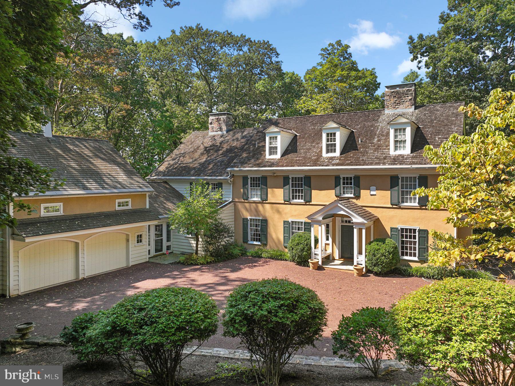 Hartswood- situated in the community of Round Hilll, and showcasing a stunning Main Residence and detached Guest House! Perched at the top of a wooded hillside, and on 5 private acres in this much sought after Upper Makefield cul-de-sac community, this gracious Trueblood-built home was inspired by an English manor home. It is finished with a stucco façade, cedar shake roof, and offers handsome millwork, generous scale to all rooms, 5 wood-burning fireplaces, and dark-stained random wood board flooring on the two main living levels. The 4 Bedroom, 4.1 bath home, and detached 1+ bedroom guest house enjoy total privacy and a stunning wooded natural setting. A long driveway approach takes you past the guest house and into a parking court finished with a stone retaining wall surround. As you enter the front foyer of the main home, a commanding staircase with a landing and window seat, along with two-story windows greets you. The foyer is flanked by a home office with Mercer tile fireplace, and an inviting formal dining room. A guest powder room is nearby. The step-down formal living room with fireplace and built-ins leads through glass French doors to an outdoor terrace with stone retaining wall and magnificent views of the countryside and western sunsets. A 2-story step-down family room has a commanding brick walk-in fireplace with wood stove insert, wall of windows, and built-ins with a bar sink and refrigerator – a perfect venue for everyday living and entertaining. The custom kitchen with charming breakfast room and French doors to an outdoor side terrace is finished with granite counters and stainless appliances including a 4-burner GE Café gas cook-top, double GE Café wall ovens, Subzero refrigerator, Bosch DW, a Butler’s pantry area, and more. Close by is the laundry with built-ins and a utility tub, and there is a full bath with shower on the main level. Between the main house and garage is a wonderful, screened porch for easy living, dining, and outdoor entertaining on summer nights! Above the garage are two rooms, a great space for a home gym or secluded home office. The 2nd floor of the home offers 4 spacious BR’s and 3 baths. The main bedroom is grand in scale, with sitting area with Delft tile fireplace, and toe balcony w/French doors for outdoor views. A large walk-in closet is enhanced by an entire closet and dressing room on the walk-up third floor level, complete with 3-way mirror, cedar closet, and room for clothing and shoes galore. The renovated main bath (2006) with steeping tub and corner shower is beautifully finished. One spare bedroom is a princess suite w/fireplace and full bath, and two additional bedrooms, share a hallway bath. The part-finished lower level with tile flooring is great for wine-tasting and is equipped with a climate-controlled wine cellar. Separate and apart is a guest house, well-designed and beautifully finished with a cherry kitchen with gas range, living/dining room areas with wood fireplace, home office and 1 BR 2.1 baths. It is spacious, sunny, and ideal for extra living quarters or a home office. This home and property offer many additional features- Pella windows and French doors, zoned Geothermal HVAC, a whole house generator which includes the guest house, exterior lawn irrigation, and two septic systems. This stunning home, finished with lush professional landscaping and hardscaping, offers breathtaking views- perfect for the buyer with quality in mind!