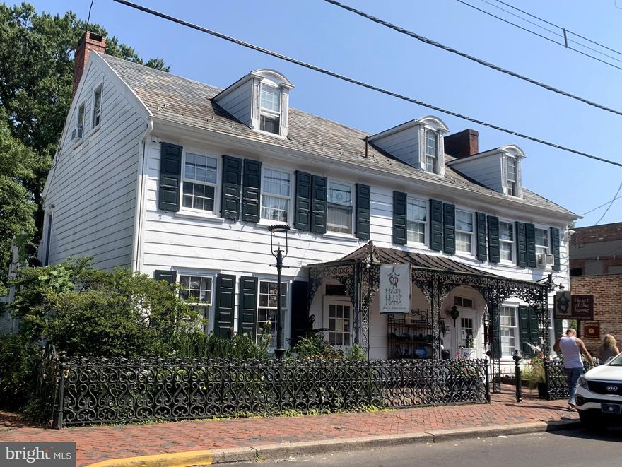 Available for the first time in two decades: one of the most prime commercial locations in all of downtown New Hope offers historic charm, multiple income-producing units, and one of the largest pieces of riverfront green space anywhere in town.  Dating back to the late 1700's and widely considered the oldest wood-frame home in New Hope, the main building is prominently situated in the fine dining/shopping district (flanked by the Ferry Market, Logan Inn, Marsha Brown's and Mansion Inn, just to name a few) and currently offers over 2,500 sq ft of showroom space indoors and out plus top floor offices.  A partitioned second floor apartment within the main building could offer additional income, a work-where-you-live option, or expand the commercial space to incorporate the entire building.  The layout of the main level could also lend itself to dividing into two shops, or wherever your creative vision takes you!  Down either of the two (2!) herringbone brick driveways and you'll enter a "secret garden" world of the sprawling back yard, lined by rented cottages, which leads to the 80+ feet of continuous river frontage mostly consisting of stone patio seating areas.  In the cooling shade of a 200+ year old willow tree (recognized by the National Arborist Association as significant) the three residential rentals and one commercial tenant enjoy an exclusive enclave that never suffers long from vacancies.  Walk down the stone steps to the river's edge and boat dock, and soak in the views of the sunrises/sunsets.  Opportunity knocks to bring your business vision to this truly one-of-a-kind property.