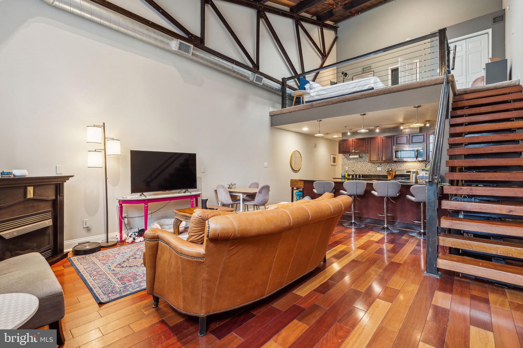 Loft-Style Living with Private Entrance + Parking in the Heart of Fishtown! Welcome to Thompson Street Lofts at 1301 N Front St, Unit D—a rare opportunity to own a beautifully designed industrial-style loft in one of Philly’s most vibrant neighborhoods. With a Walk Score of 96, this location puts you right in the center of the action, while offering the convenience of a private entrance and dedicated parking just steps from your front door. This spacious 2-bedroom, 2-bathroom home features nearly 25-foot ceilings, two skylights, and striking exposed wood and steel beams that bring warmth and character to the space. Natural light pours in, highlighting the floating reclaimed wood staircase, exposed brick, and hardwood floors throughout the open-concept living and dining area. The kitchen is outfitted with an island that’s perfect for everyday use or entertaining guests. On the main level, you'll find a cozy back bedroom with two large closets, a laundry room, and a stylish full bath with a raised jetted tub. Upstairs, the lofted second bedroom offers the perfect work-from-home setup and overlooks the living space with a bright, open feel. The ensuite bath features a frameless glass walk-in shower with a built-in bench and exposed steel details for that refined loft aesthetic. Outside your door, some of Philly’s top dining destinations are just a short stroll away: Front Street Café (directly across the street!), Suraya, Wm. Mulherin’s Sons, Laser Wolf, LMNO, Kalaya, and Hiroki, to name a few. Morning coffee, weekend brunch, or a night out—all just minutes from home. Commuting is easy with immediate access to I-95, and the Girard El station is just a block away, offering a quick ride to Center City, Northern Liberties, and beyond. Stylish, functional, and perfectly located—this unique home has it all. Schedule your showing today!