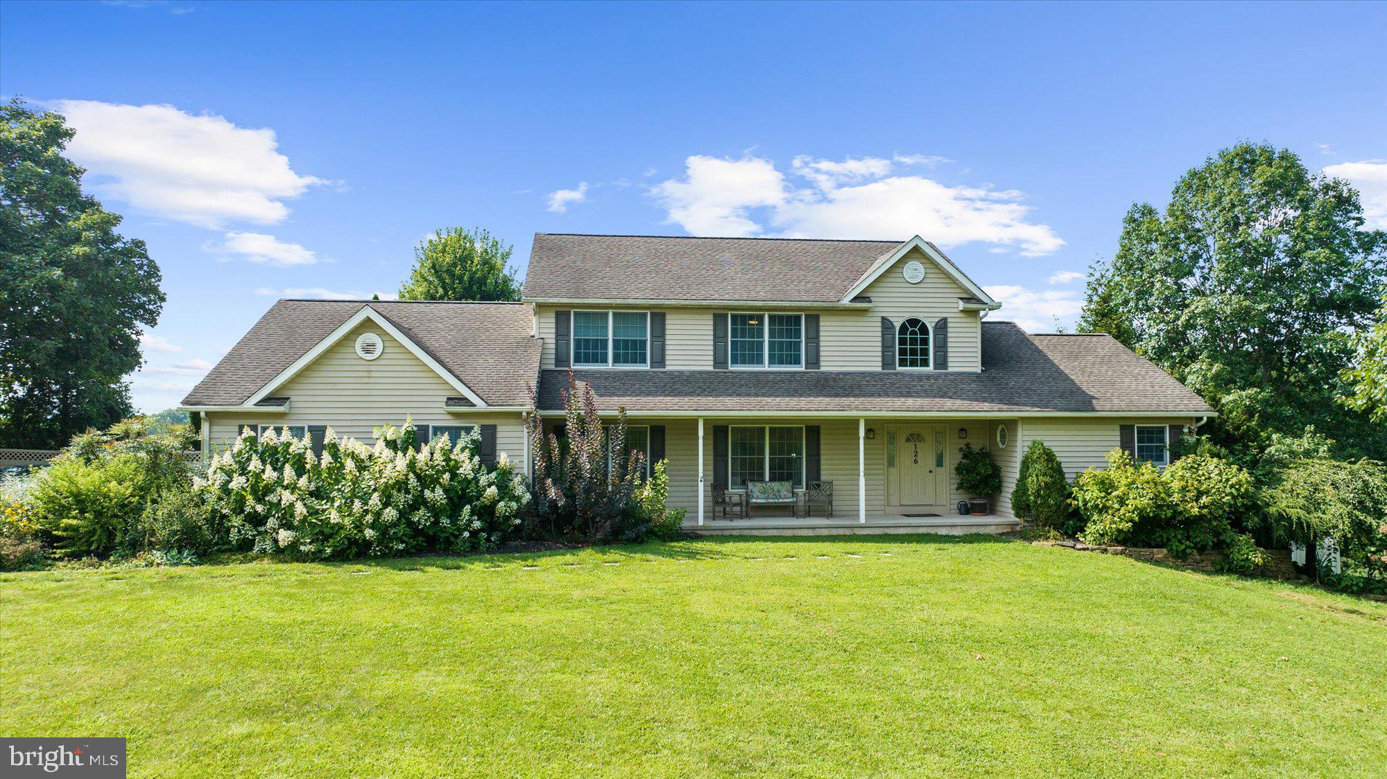 Custom country home overlooking an acre of ground and a neighboring nature preserve, with the most breath-taking sunsets...This Welbilt custom home offers six bedrooms and 3.5 baths, thoughtfully designed for comfort and practicality, with lots of usable space. Tucked into the peaceful countryside with serene views of a protected nature preserve from the covered expansive deck, it blends modern features with timeless charm. Inside, the extensive kitchen features walk-in pantry, quartz counters, trash compactor, a double wall oven, electric induction cooktop—all open to the inviting family room with pellet stove insert. The laundry room, powder room, garage, and mudroom are all conveniently placed off of the kitchen with side access to the driveway and gate through privacy fence to an acre+ of expansive ground. Pull-down stairs in the garage lead to floored attic area for storage. There are French pocket doors that separate the formal living room and dining room, along with double French doors to foyer. Many rooms on the main level are versatile and can be used as either dining room, office, or formal living space. The first-floor primary suite includes a walk-in closet, cozy window seat with built-in storage, and a luxurious bath with rain showerhead, corner jetted tub, and private water closet. A quaint library area separates the main bedroom from the rest of the main living space. Upstairs, can be found an inviting reading nook with built-ins, four spacious bedrooms, and a full hall bath with double vanity, separate toilet area, and an oversized linen closet—plus a convenient laundry chute to the main level. The full daylight basement offers high ceilings, a propane fireplace, a full bath with shower, plentiful utility space, and the sixth bedroom (presently used as an office). Double glass doors lead to the beautifully fenced yard dotted with native Pawpaw trees, apple tree, blueberry and fig, and an expansive inviting deck—perfect for enjoying breathtaking sunsets. HVAC replaced in 2019, Artesian well, septic pump more recently replaced, owned propane tank, 200 amp electric service, block construction. Such a beautifully thought-out floor plan, with plentiful natural light and space, on an equally impressive piece of ground.