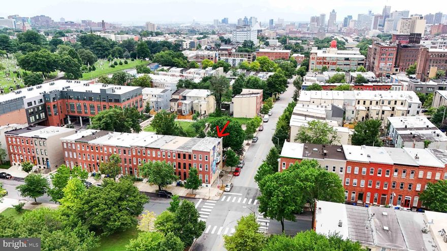 Discover this exceptional end-of-group Baltimore row home in the vibrant and thriving STATION NORTH ARTS DISTRICT, showcasing a striking exterior mural by renowned artist Ernest Shaw, Jr.  This is far from your typical row home-offering a rare blend of style, space and versatility in one of Baltimore's most exciting neighborhoods. Approx. 1,936 Sq ft  Situated on a quiet one-way street, the home faces lush, undeveloped green space and backs directly to a community park complete with a water feature and gated off-street parking-a true urban retreat.  Versatile layout for modern living.  The entry-level features a private bedroom suite ideal for an in-law arrangement, home office, short-term rental or art studio-offering flexibility to suite a variety of needs. The second level boasts an open-concept living, dining area & kitchen area, filled with natural light from windows on the three sides.  The kitchen flows seamlessly into this space, creating the perfect setting for entertaining.  A conveniently located laundry area and a rear entrance provides easy access to the park and gated parking via a back staircase.  Upstairs, the top level includes a spacious bedroom, a large central bathroom with a soaking tub and an additional front-facing bedroom.  Close proximity to Penn Station, entertainment venues, dining and cultural attractions.  Welcome home.