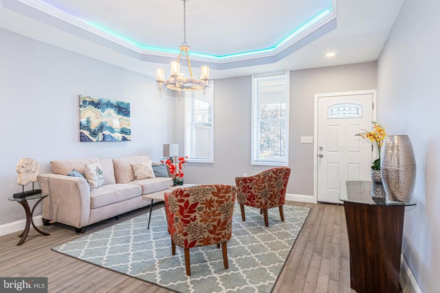 EXPANSIVE RENOVATED PORCH FRONT ROWHOME WITH APPROXIMATELY 2,700 SQ. FT. OF LIVING SPACE!  Features include a spacious living room and separate dining room with tray ceilings and rope lighting, designer island kitchen w/ ss appliances, granite counters, & tile backsplash, main level half bath, upper level with 3 bedrooms and 2 full baths including a Primary bedroom suite with a full bath, fully finished basement with a family room, 2 bedrooms, and 1 full bath.  Located close to Coppin State University!