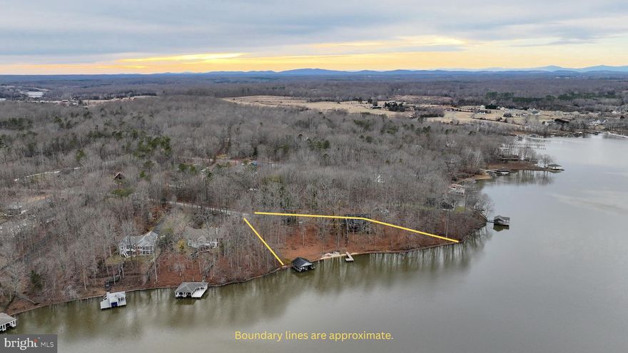 Wide, unobstructed shoreline with approximately 400± feet of waterfront sets the foundation for this public-side Lake Anna property. Set on 1.14 acres with a private paved driveway, this 4-bedroom, 2.5-bath home (3-bdrm septic) offers expansive water views, strong waterfront presence, and convenient access to Route 522 for shopping, dining, and marinas. The open-concept design features soaring two-story ceilings, exposed wood beams, and abundant natural light, creating an inviting main living area. The kitchen is equipped with granite countertops and flows seamlessly into the living and dining spaces. The main-level primary bedroom includes an ensuite bath for added convenience. The finished walkout basement provides additional living space with a spacious rec room, offering flexibility for guests or extended stays. Outdoor living is where this property stands out. Multi-level decking with wire railings maximizes lake views, while the private boathouse with dual lifts, an additional waterfront pier, and updated composite decking enhances both function and durability along the shoreline. Updates completed in 2021–2022 include a new roof, new skylights, flooring, and two new HVAC systems. A detached carport provides additional covered parking. With substantial shoreline frontage, public-side access, and major system improvements already in place, this property presents a rare opportunity to secure a significant Lake Anna waterfront setting.