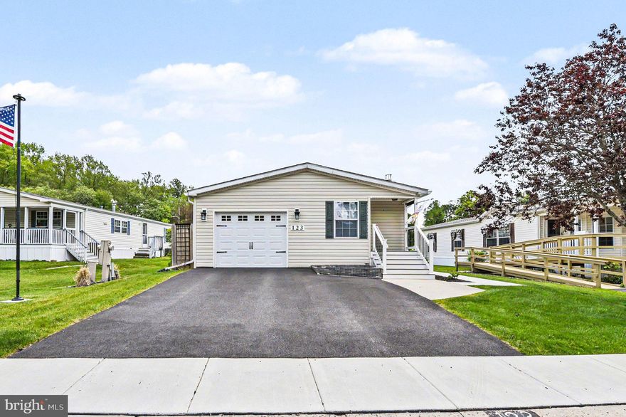 Beautifully maintained and recently updated, 2-bedroom, 2 full bath manufactured rancher ("Delaware" model) offering 1,384 sq. ft. of living space and located in the sought-after 55+ community of Cecil Woods with close proximity to Rt 40, I-95 and the shops and restaurants of the quaint and historical town of North East, Maryland. As you enter you will be greeted with vaulted ceilings, crown molding, custom floor and window trim, as well as recently added LVP flooring throughout. Highlights include a spacious living room with a cozy freestanding propane fireplace, formal dining with a striking accent wall, and a sizable eat-in kitchen with convenient garage access. Details include a new island, Corian countertops, new stainless-steel appliances, shiplap accent walls, plenty of cabinetry and prep space and sleek subway tile backsplash. Primary bedroom features include an attached bath with a new roomy walk-in shower with glass doors, new 60" vanity and updated lighting, Additional details include a sizable second bedroom, updated full bath and laundry accessed by a stylish barn door.  Exterior details include new landscaping, updated composite decking, concrete patio with a gazebo and a SunSetter retractable awning. Additional upgrades include insulated garage (ceiling and main wall) with epoxy flooring, new driveway, new shed, 6" gutters added in 2026, fresh neutral paint throughout, new storm doors and much more! (see full seller provided list of upgrades in docs) The active community center features a large clubhouse that includes a kitchen, social gathering area, library, billiards, exercise room, party room/game room and walking/jogging paths. Ground rent is $665.00 monthly (no property taxes!) and includes trash pick-up, public sewer and snow removal on the streets. Buyer must receive park approval from Cecil Woods (see documents for application). If you are searching for a recently updated, immaculately maintained home, located in a peaceful and friendly community, your search is over...123 Woods Way... A PERFECT place to call HOME!!!