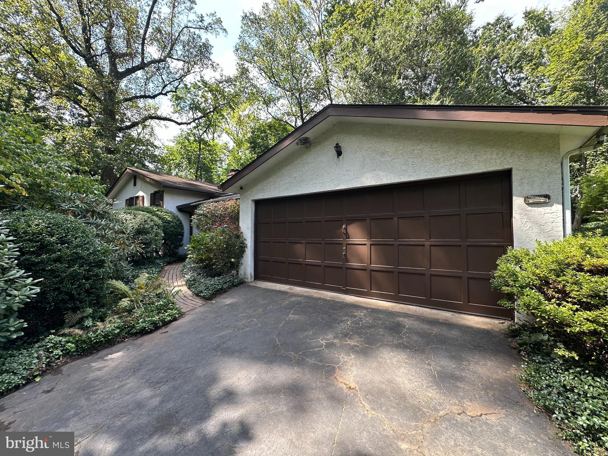 Welcome to 157 Edgewood Dr, a truly special home tucked away at the end of a quiet cul-de-sac in Ambler Borough. Set on over half an acre and bordered by 9 acres of preserved parkland, this property offers rare privacy just a short walk from Ambler’s vibrant downtown. Custom-built in 1965, this truly special home blends timeless craftsmanship with unique Swiss-inspired architectural details, including hand-carved woodwork, bronze and iron accents, and a striking, old-world entryway. Inside, the charm continues with warm hardwood floors, a cozy living room, and a kitchen with original built-ins. The spacious family room is a standout, featuring a wood-burning fireplace, beamed ceiling, brick flooring, and French doors leading to the patio and large backyard. Four bedrooms include a large primary suite with vaulted ceiling, walk-through closet, ensuite bath, and private balcony overlooking the grounds. Additional highlights include a wine cellar, large laundry/mudroom, large custom shed, and an attached two-car garage with driveway. With its combination of character, space, and walkability, this home is a one-of-a-kind retreat in a prime location.